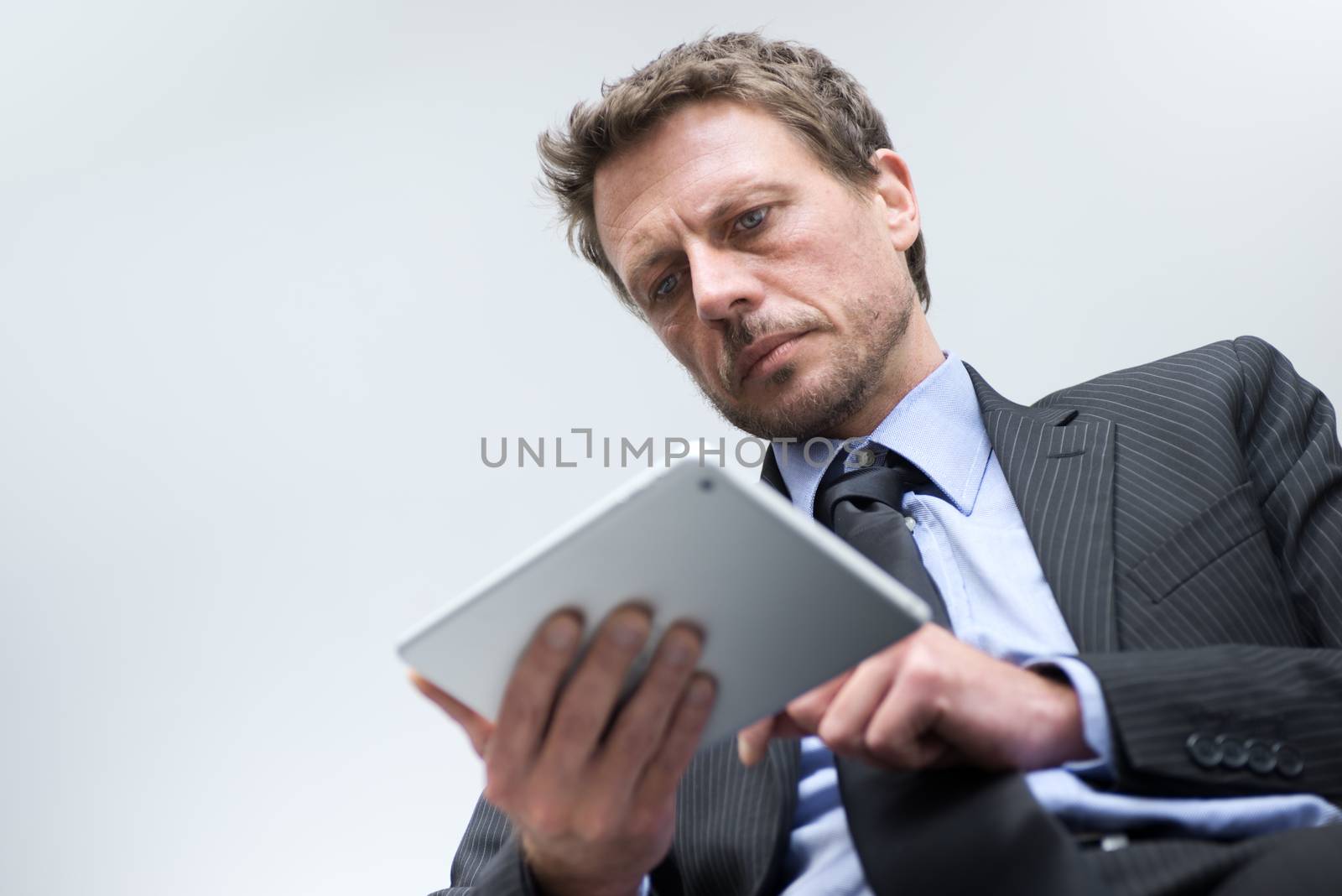 Attractive businessman working with tablet and touching digital display.