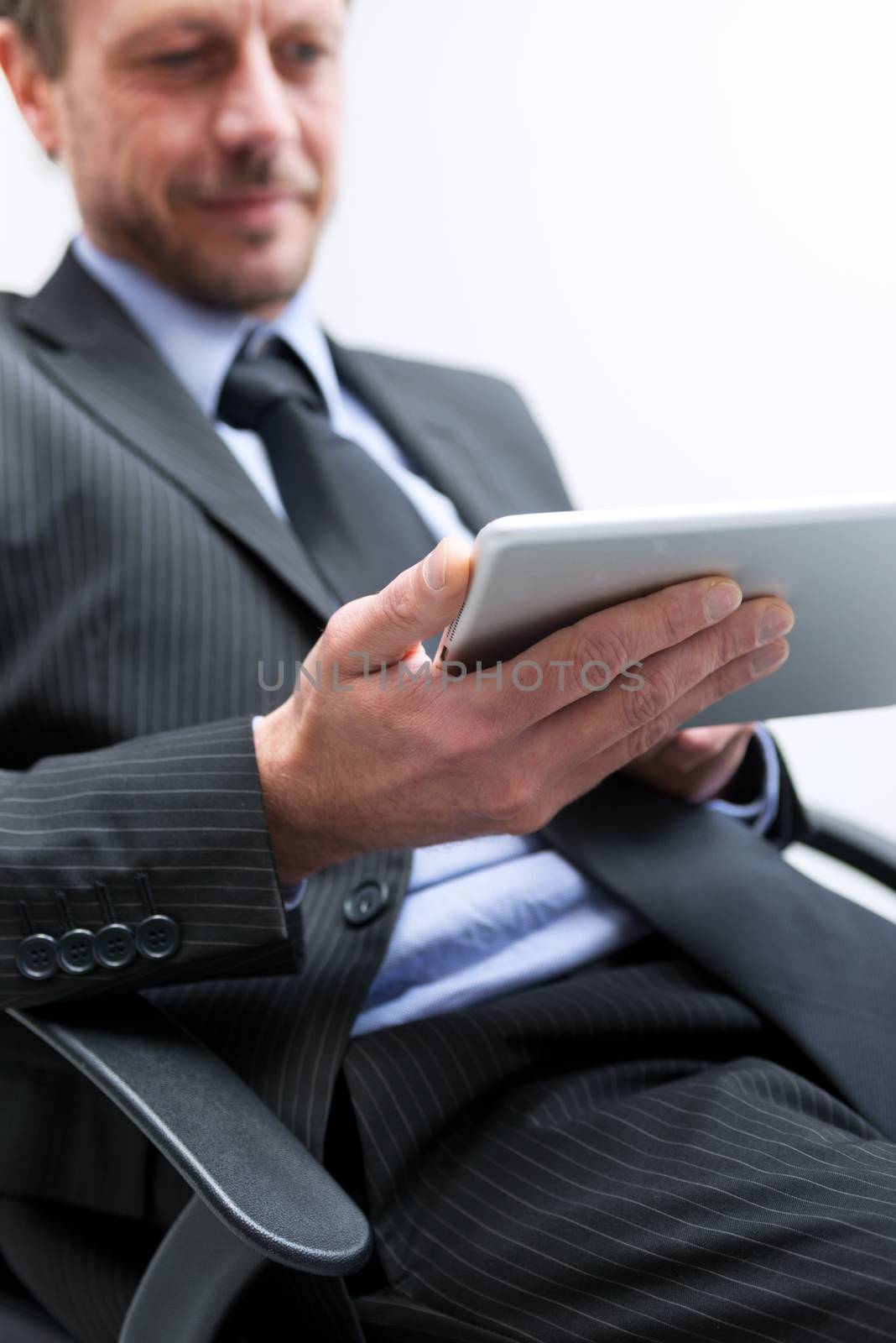 Attractive businessman working with tablet and touching digital display.