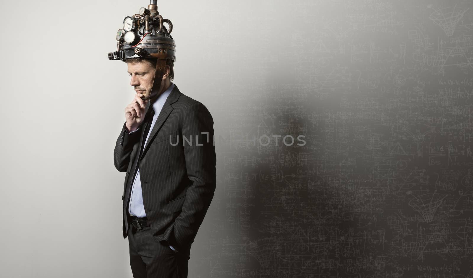Confident businessman thinking with hand on chin wearing steampunk helmet