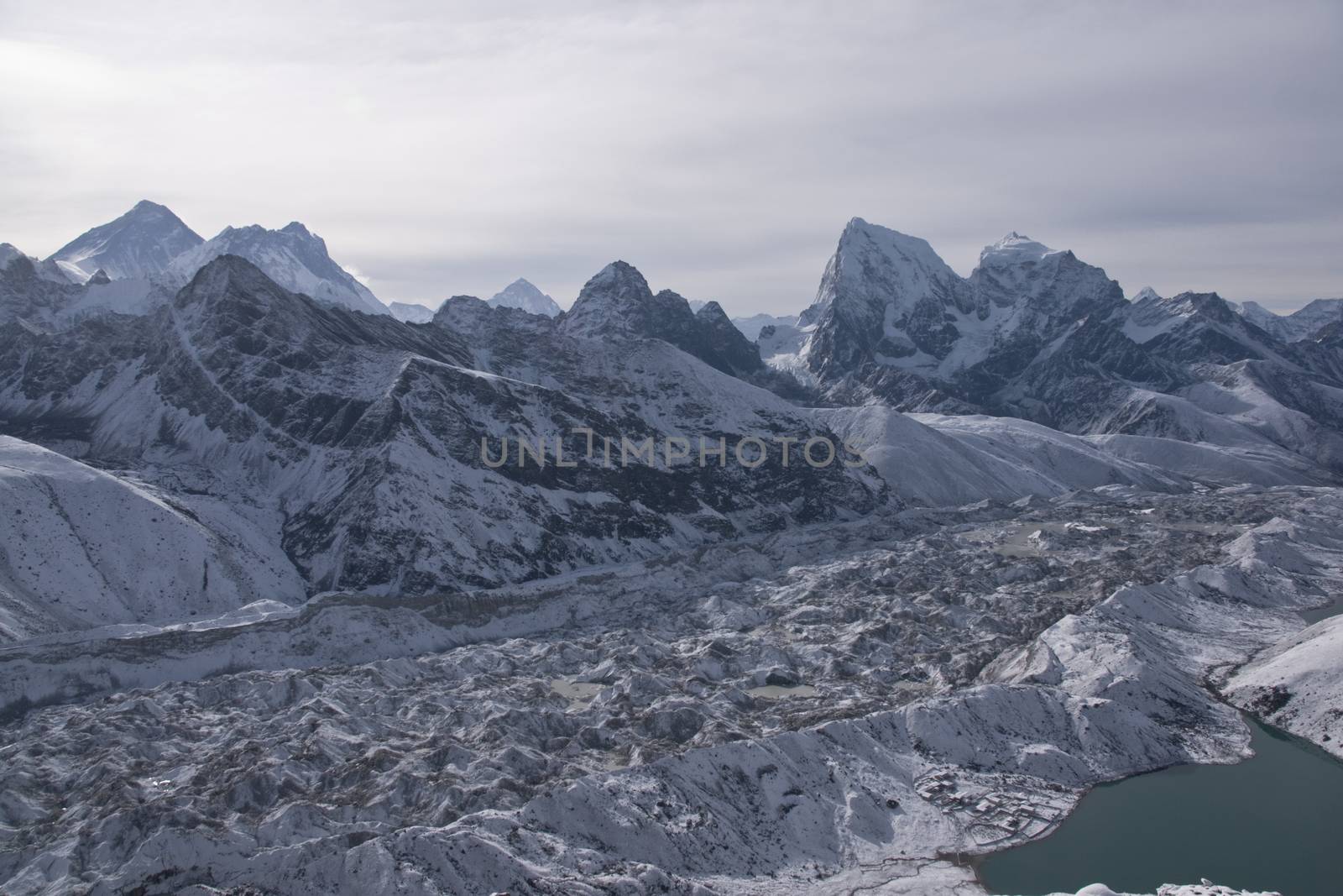 Ngozumpa Glacier dwarfs the snow covered village of Gokyo on the shore of Gokyo lake 4800 meters up in the Himalaya Mountains of Nepal.