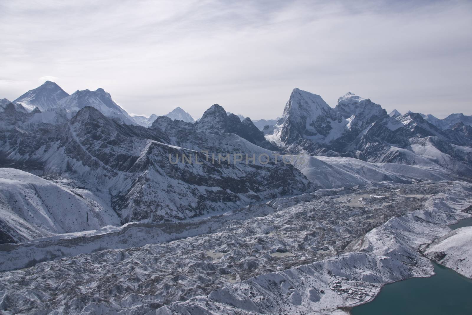 Ngozumpa Glacier dwarfs the snow covered village of Gokyo on the shore of Gokyo lake 4800 meters up in the Himalaya Mountains of Nepal.