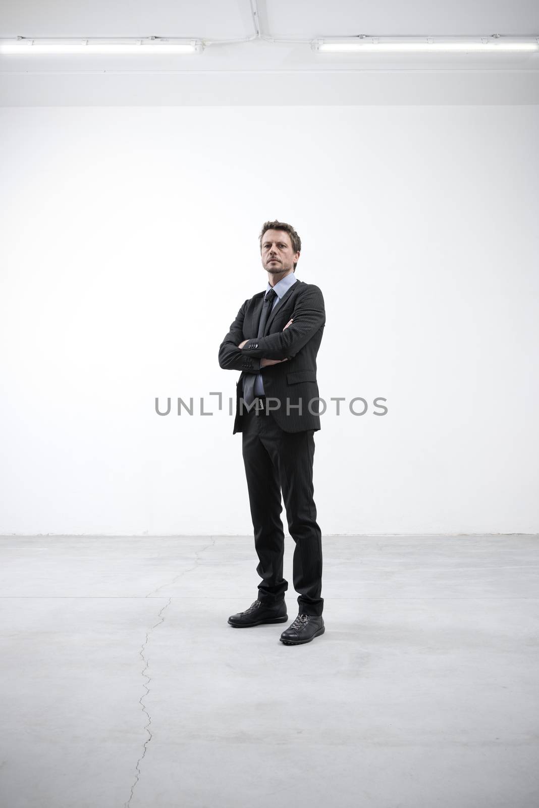 Confident businessman with arms crossed by stokkete