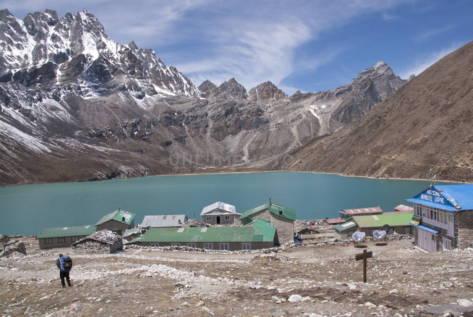 Buildings in the village of Gokyo next to a still lake and surrounded by mountains 4800 meters up in the Himalaya Mountains of Nepal.
