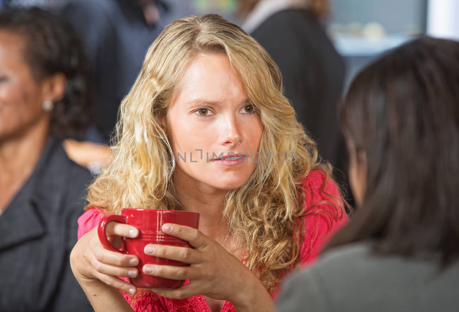 Concerned young woman talking with friend in cafe