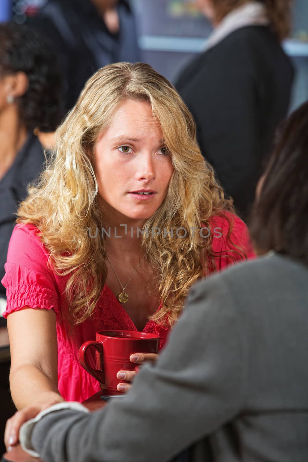 Caring young woman with friend in coffee house