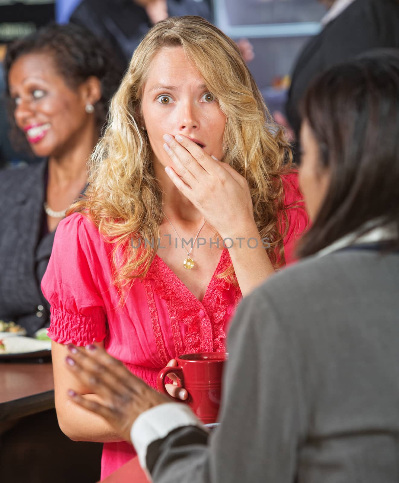 Surprised Caucasian woman with hand over mouth