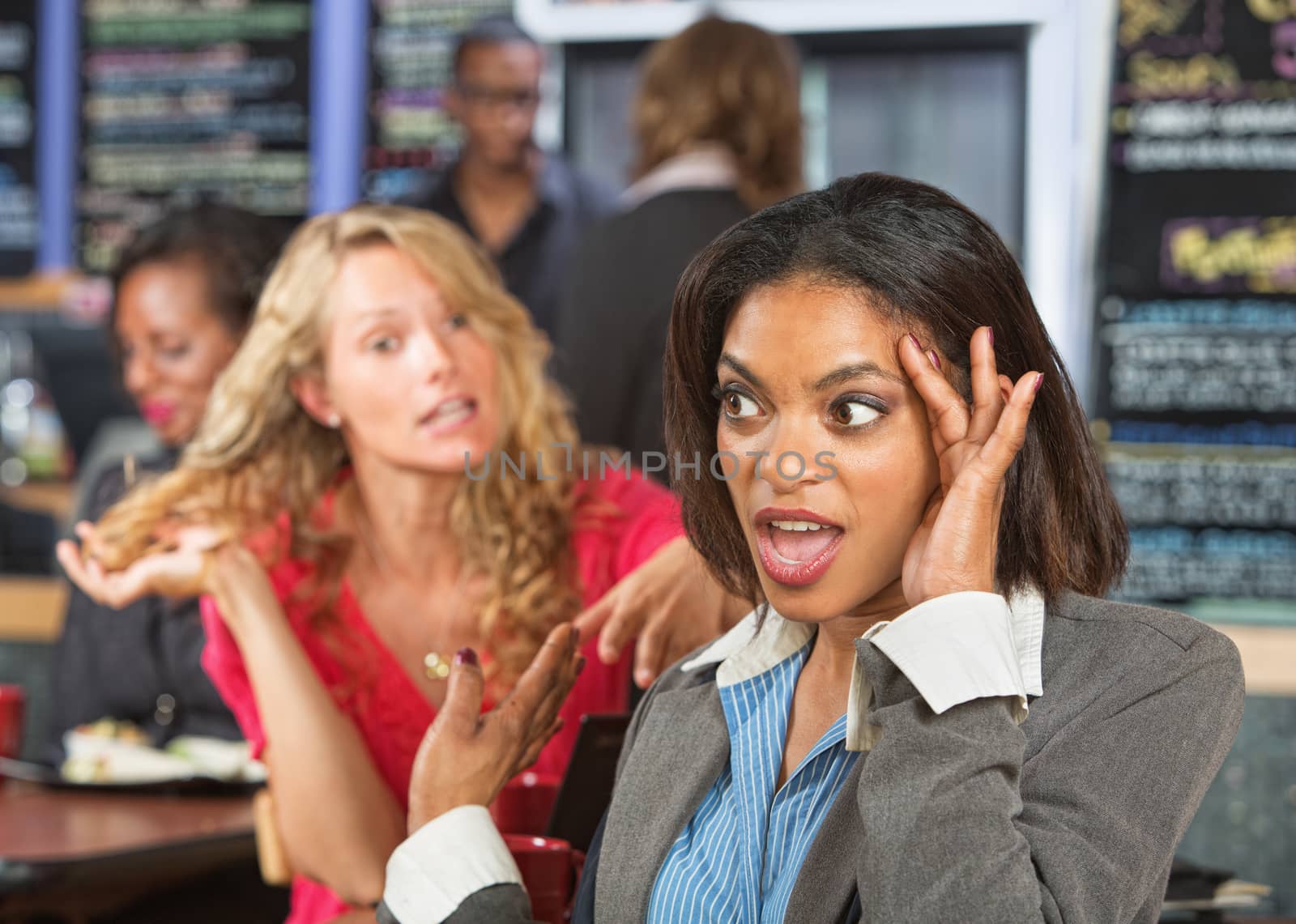 Irritated business woman listening to emotional lady