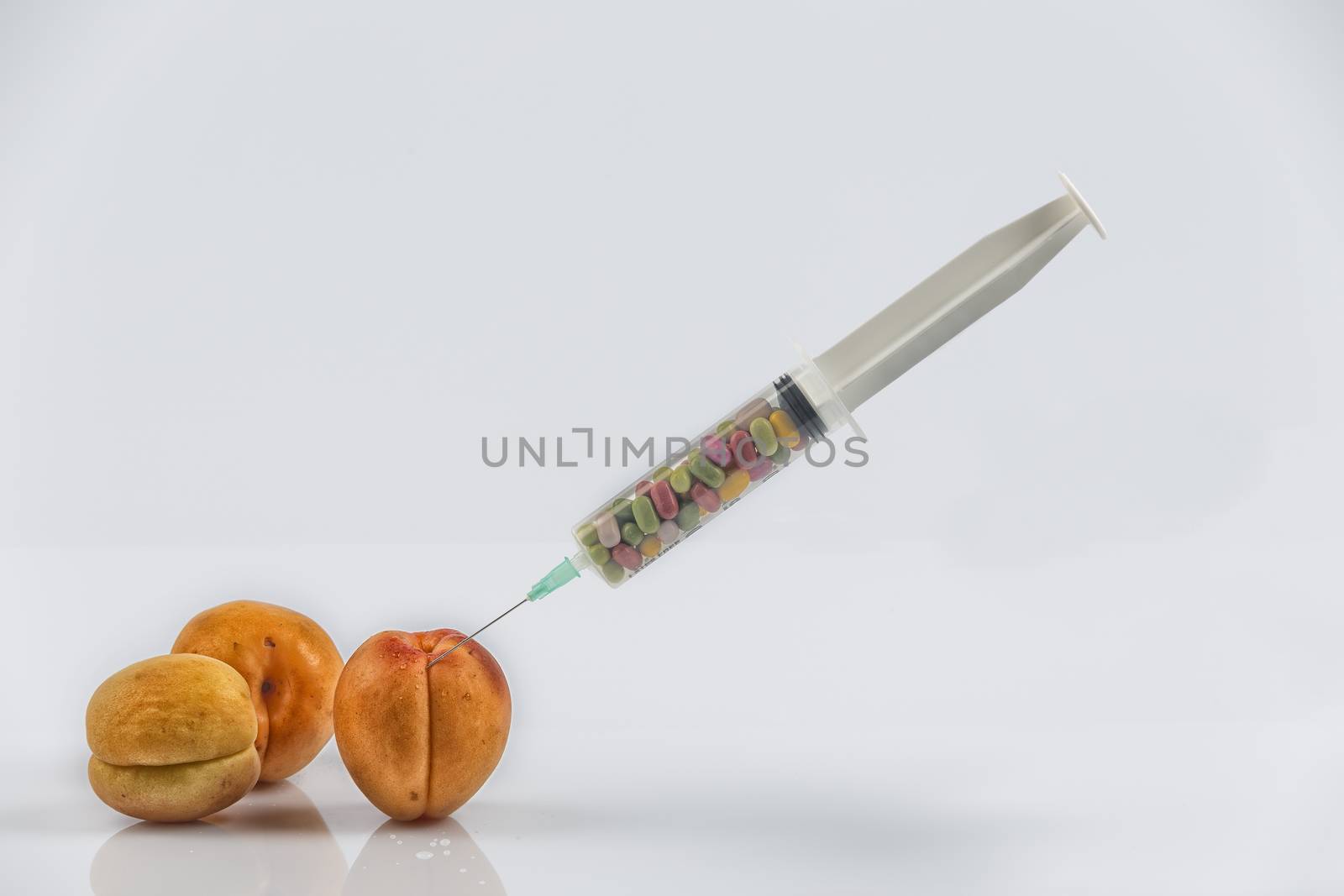 Female menopause and sexual disease metaphor: apricots and syringe with pills meaning cosmetic and health treatment for female ageing