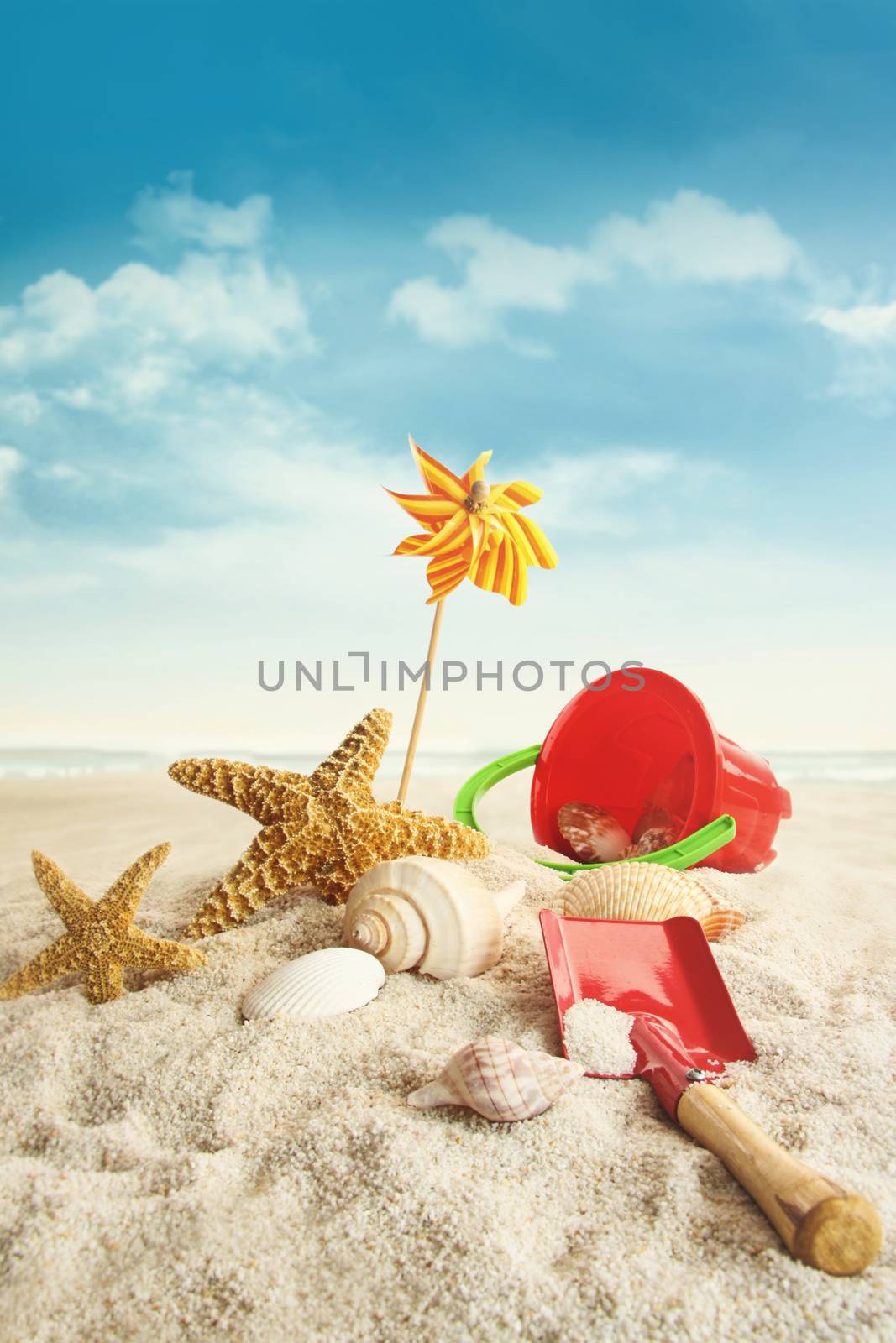 Beach toys on beach against blue sky  by Sandralise