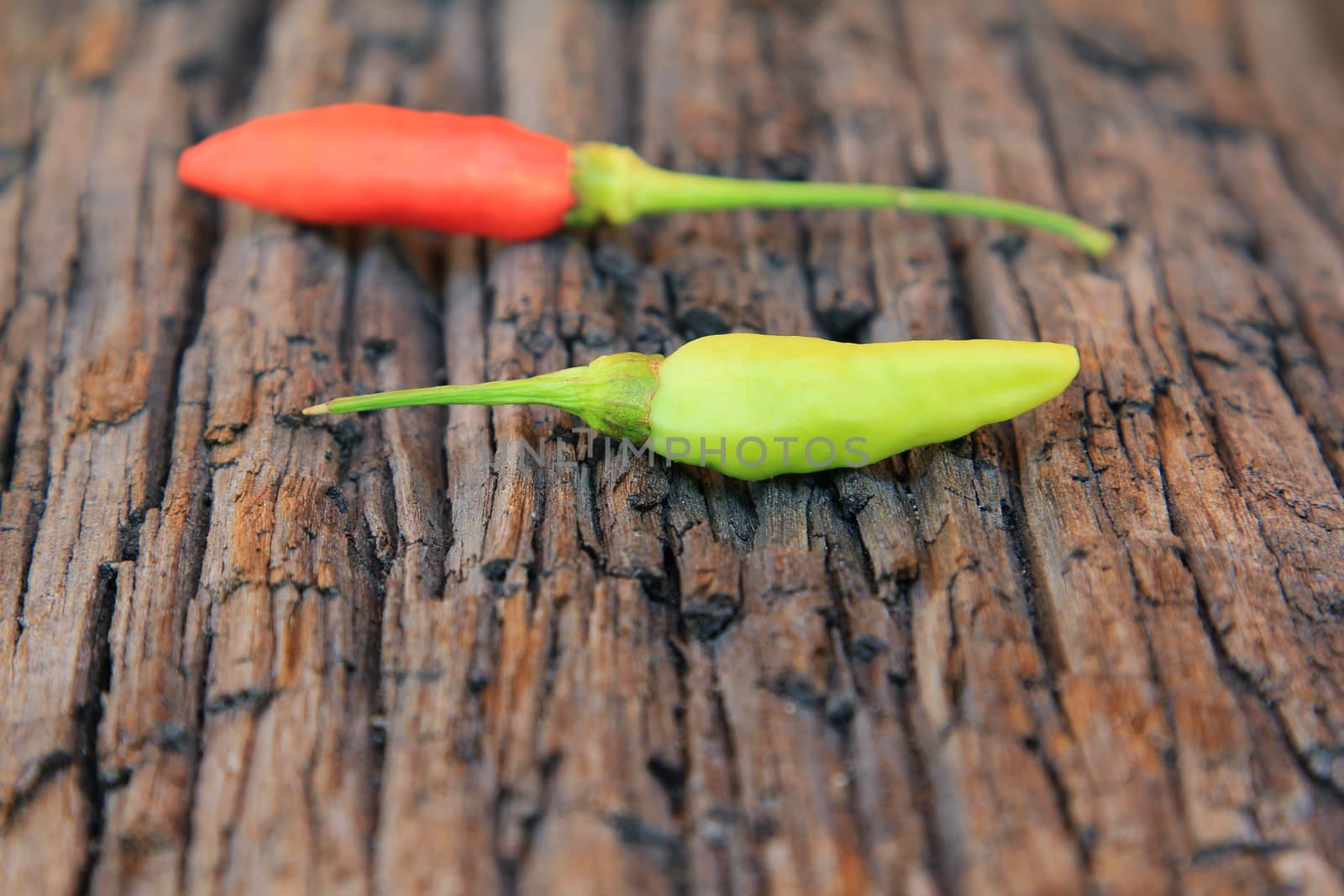 Hot chili pepper on old wooden background