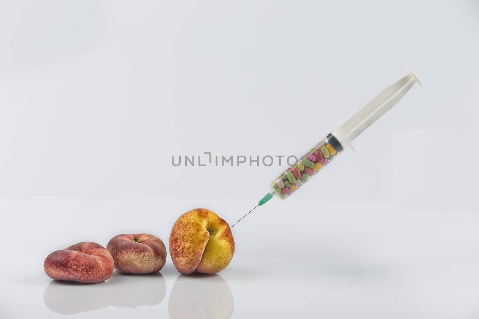Female menopause and sexual disease metaphor: peaches and syringe with pills meaning cosmetic and health treatment for female ageing