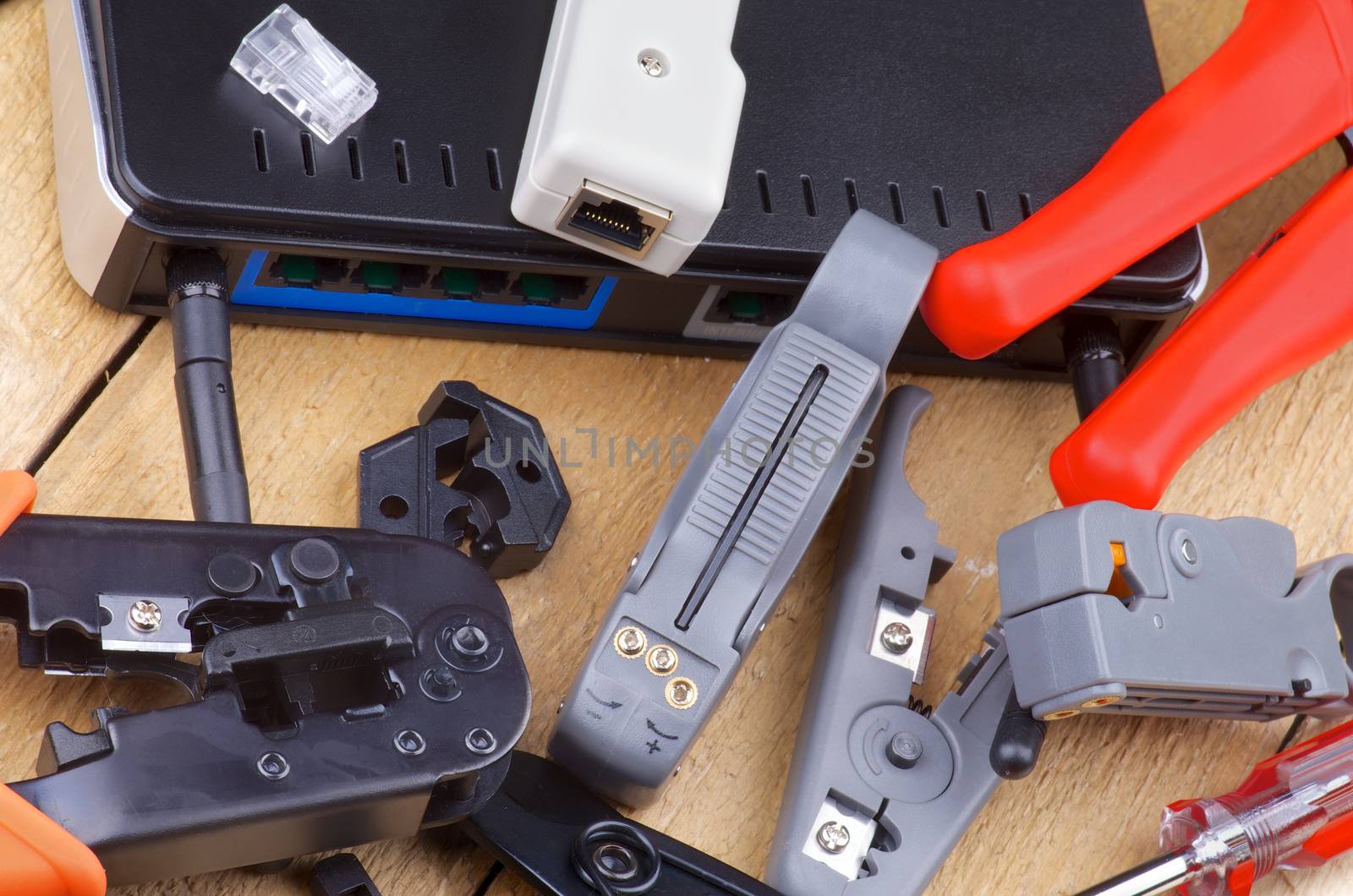 Arrangement of Computer Network Tools for Crimping, Cutting and Connecting with Router closeup on Wooden background