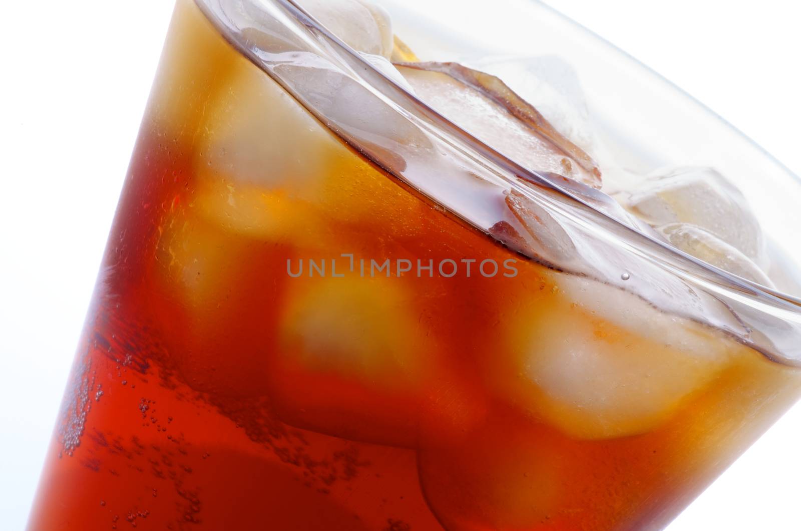 Edge of Glass with Cold Iced Cola closeup on white background