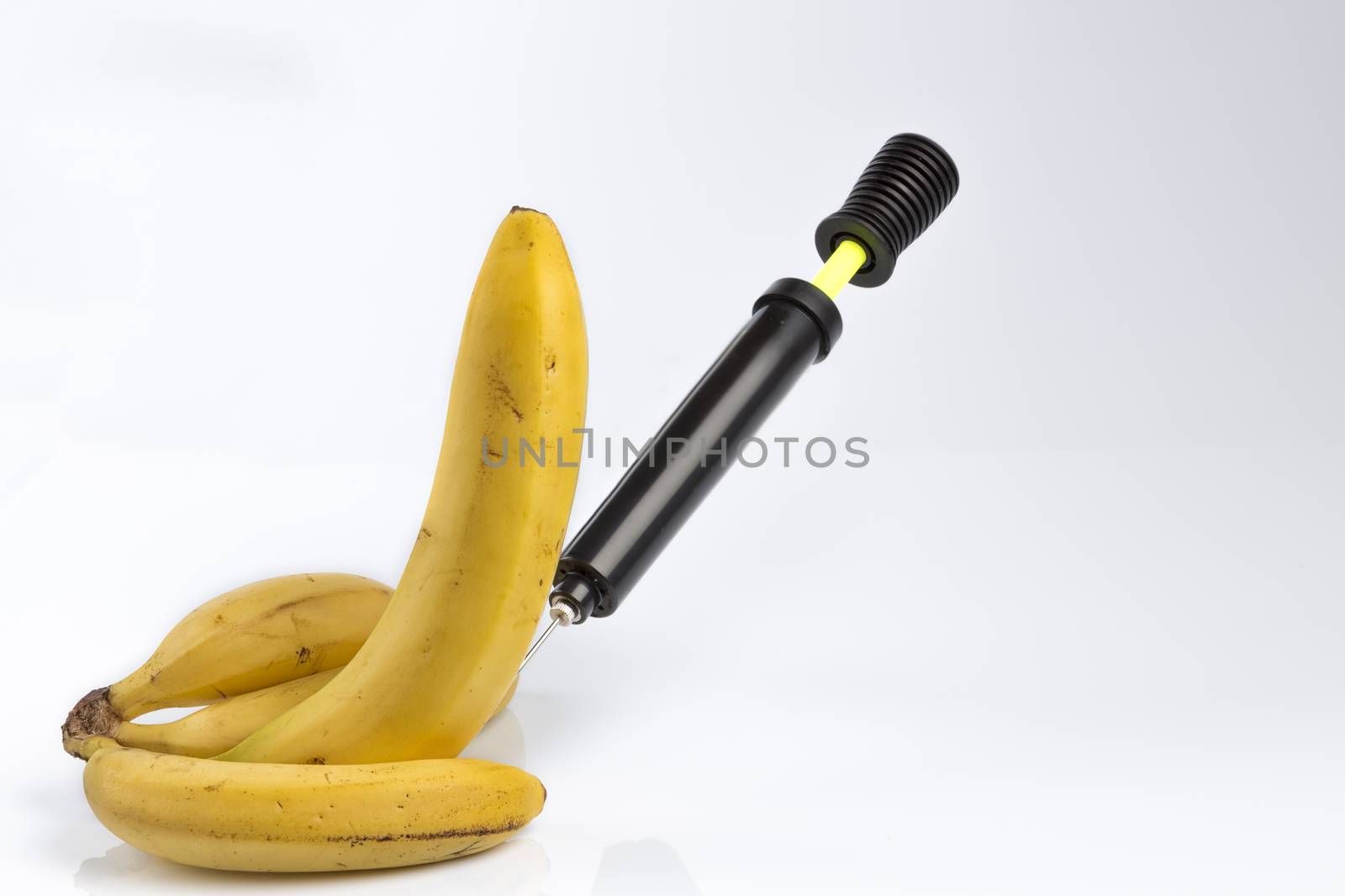 Male impotence metaphor: bicycle air pump pumping a  big banana among small bananas