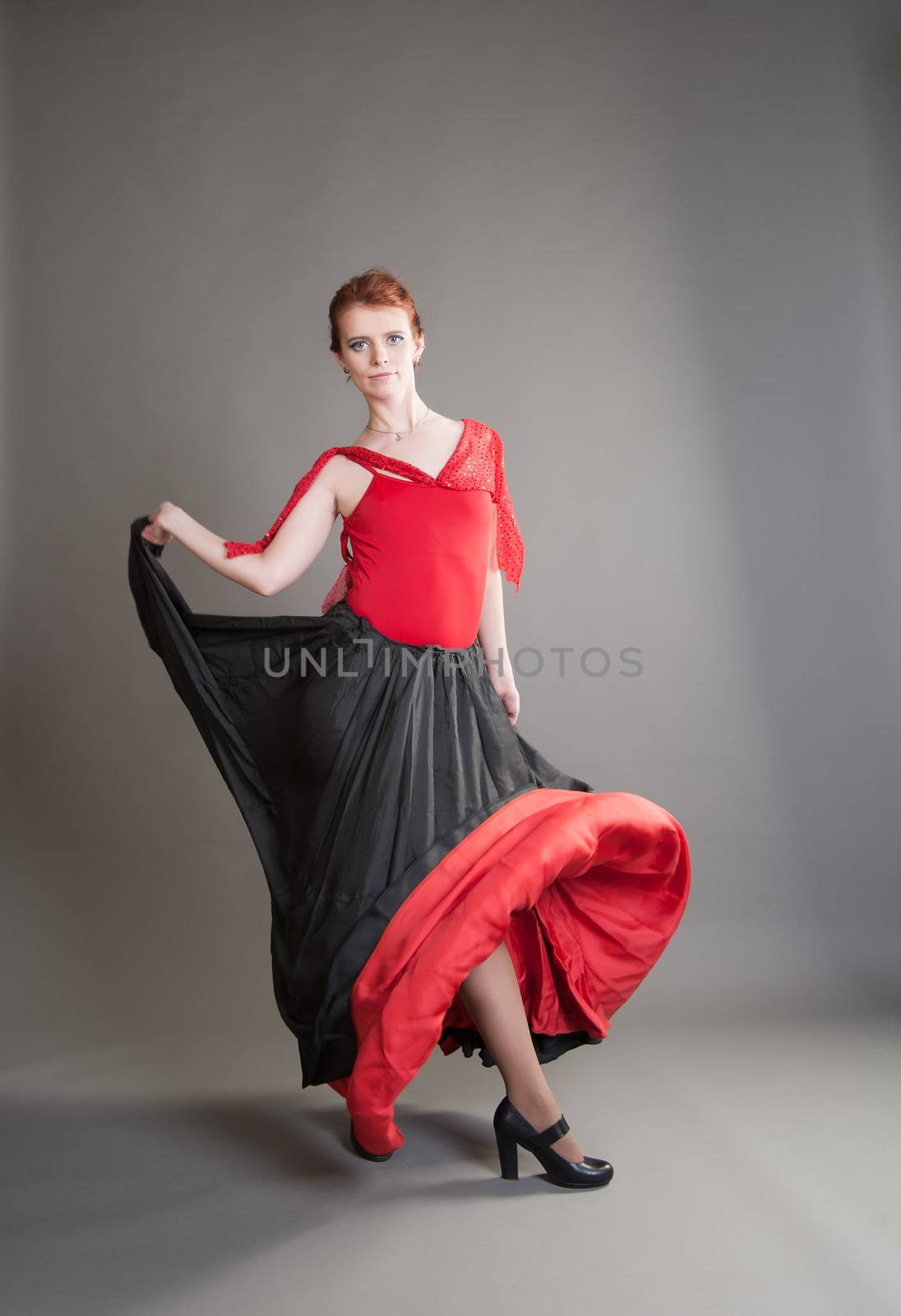 flamenco dancer swinging skirt on a grey background