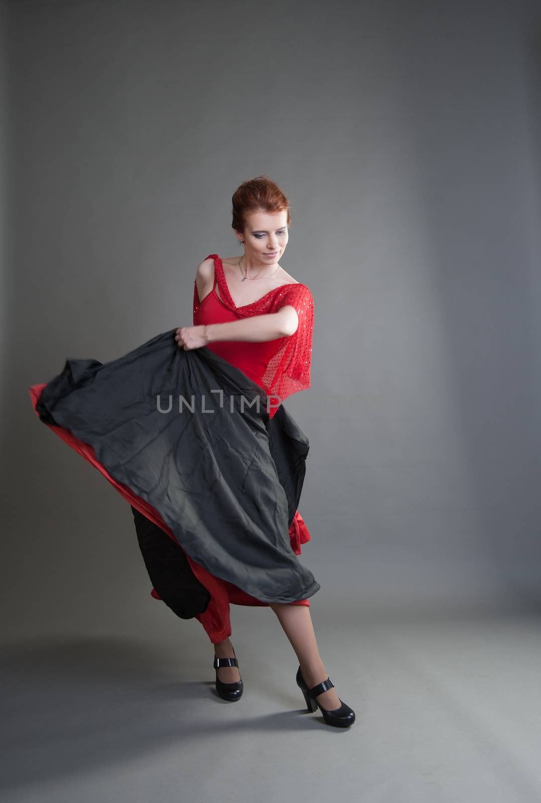 flamenco dancer swinging skirt on a grey background