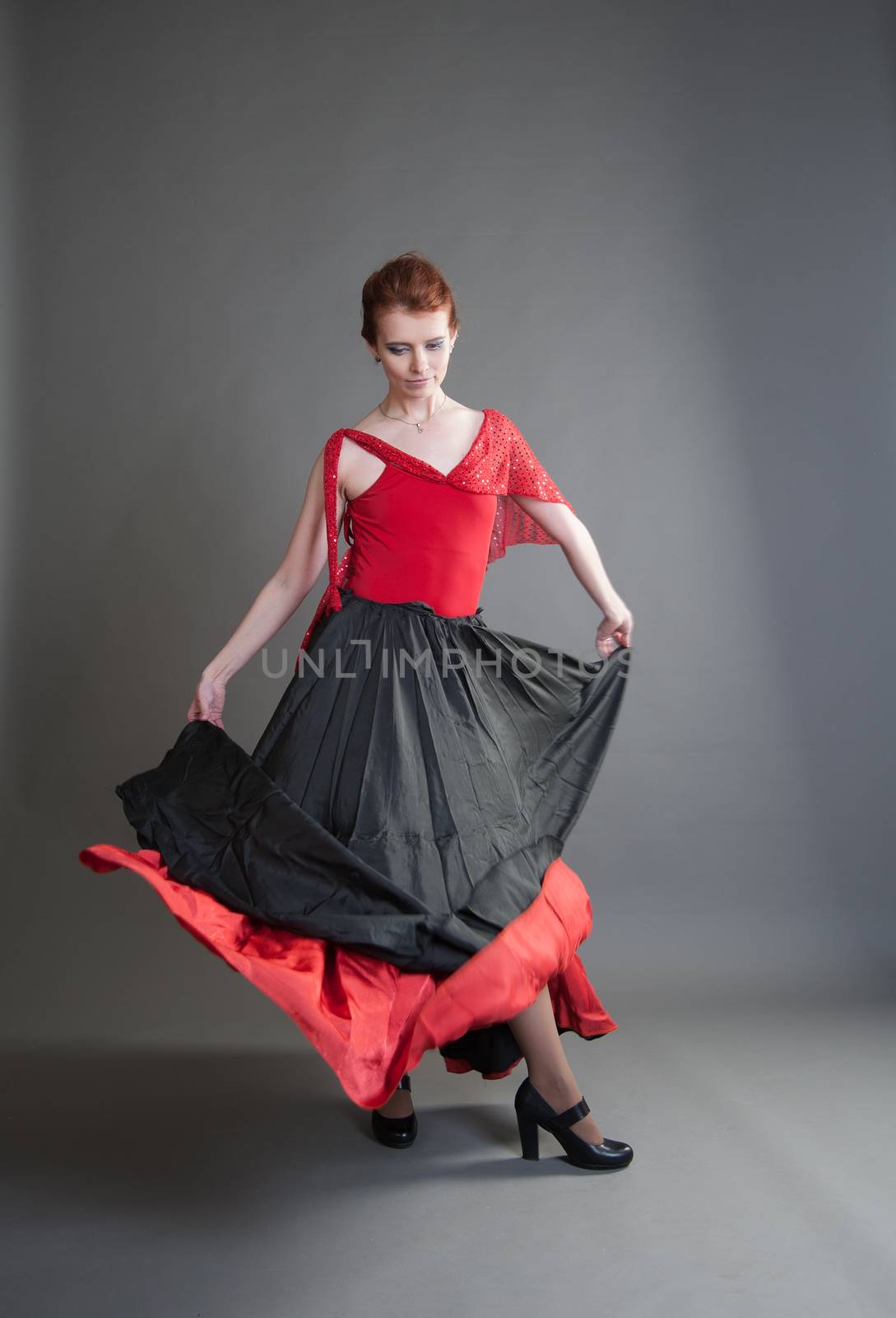 flamenco dancer swinging skirt on a grey background