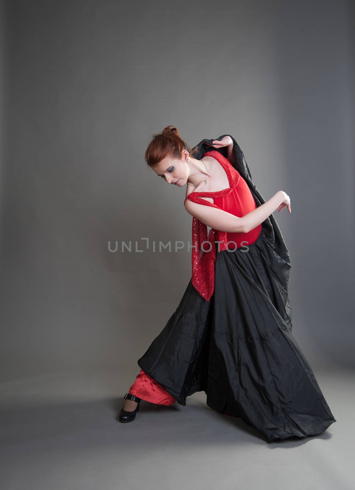 flamenco dancer swinging skirt on a grey background