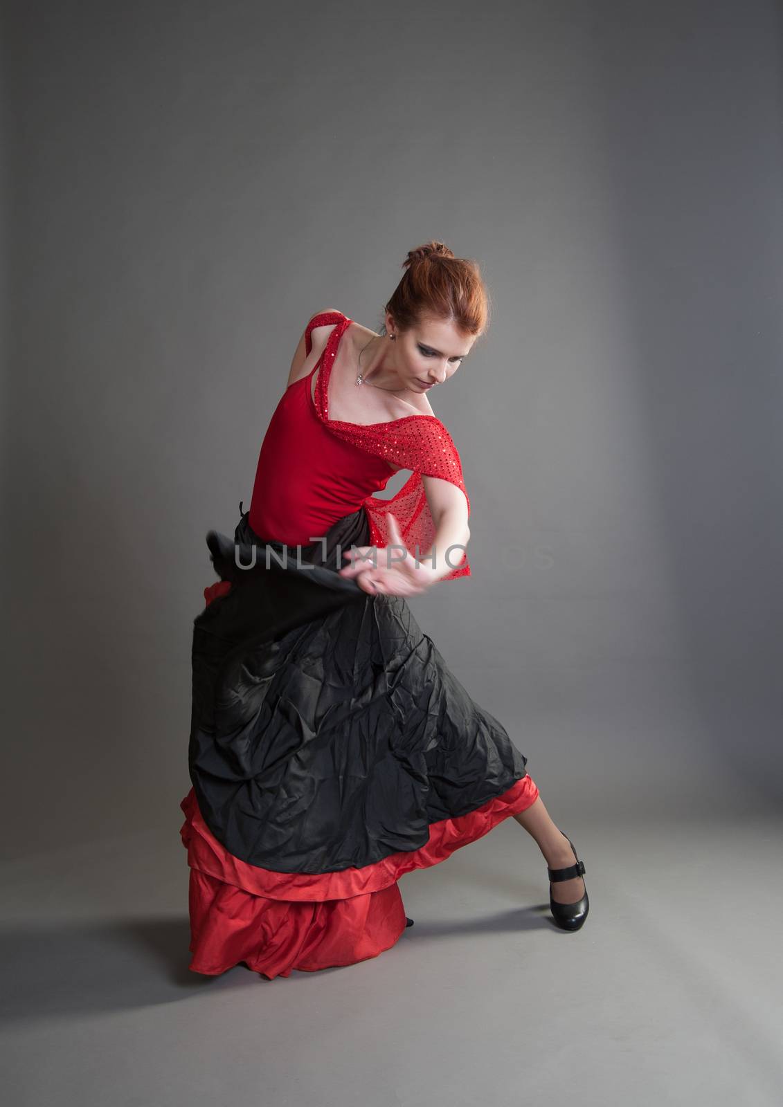 flamenco dancer swinging skirt on a grey background