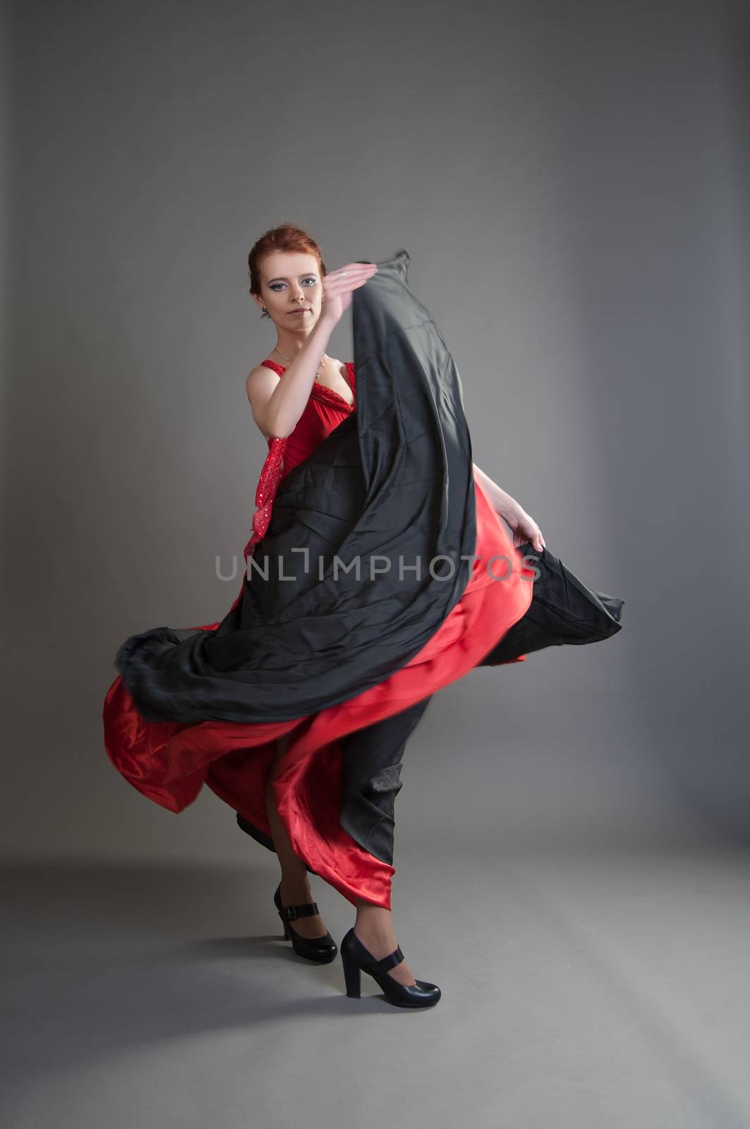 flamenco dancer swinging skirt on a grey background