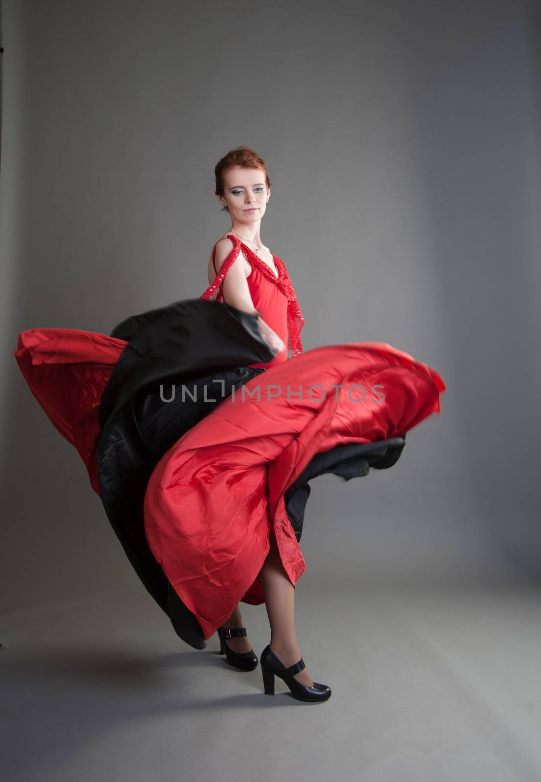 flamenco dancer swinging skirt on a grey background