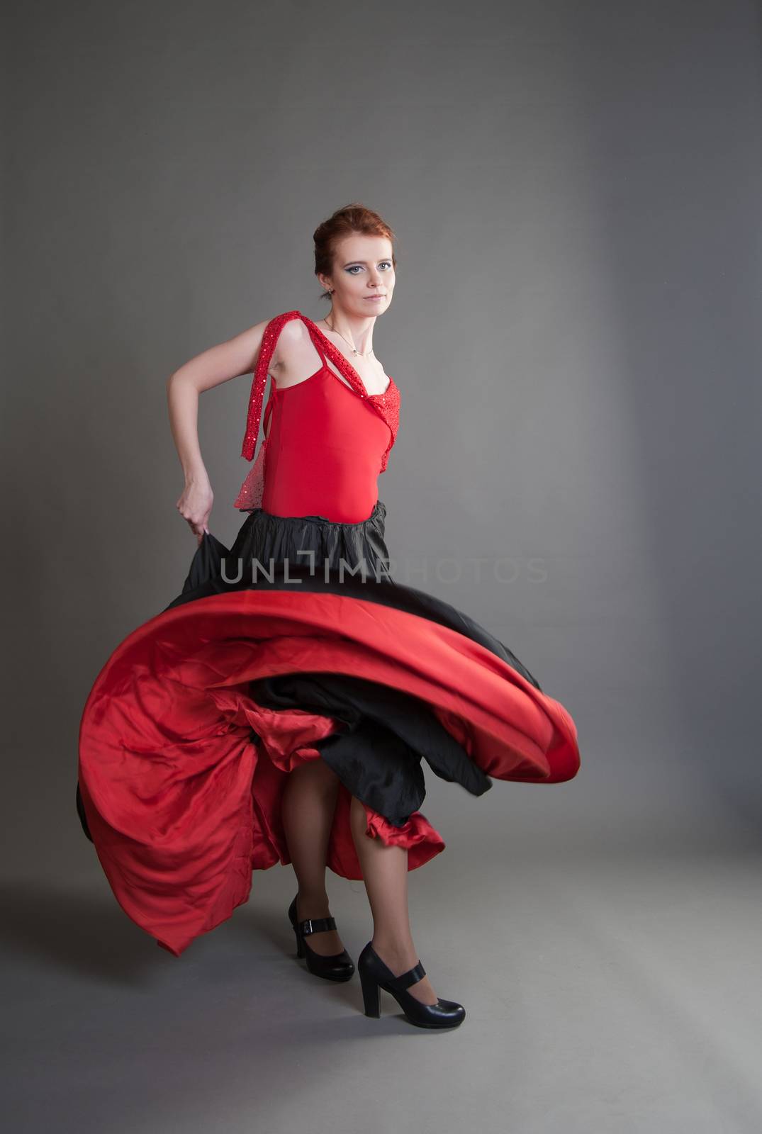 flamenco dancer swinging skirt on a grey background