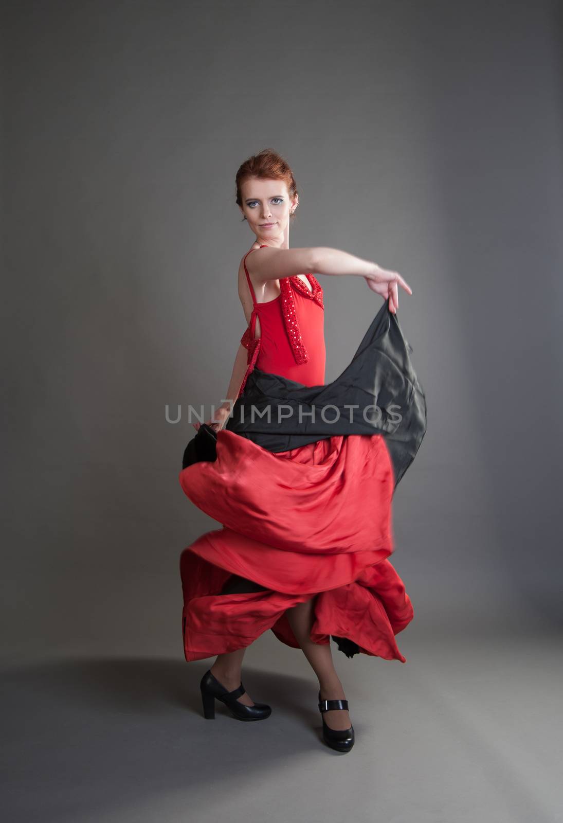 flamenco dancer swinging skirt on a grey background