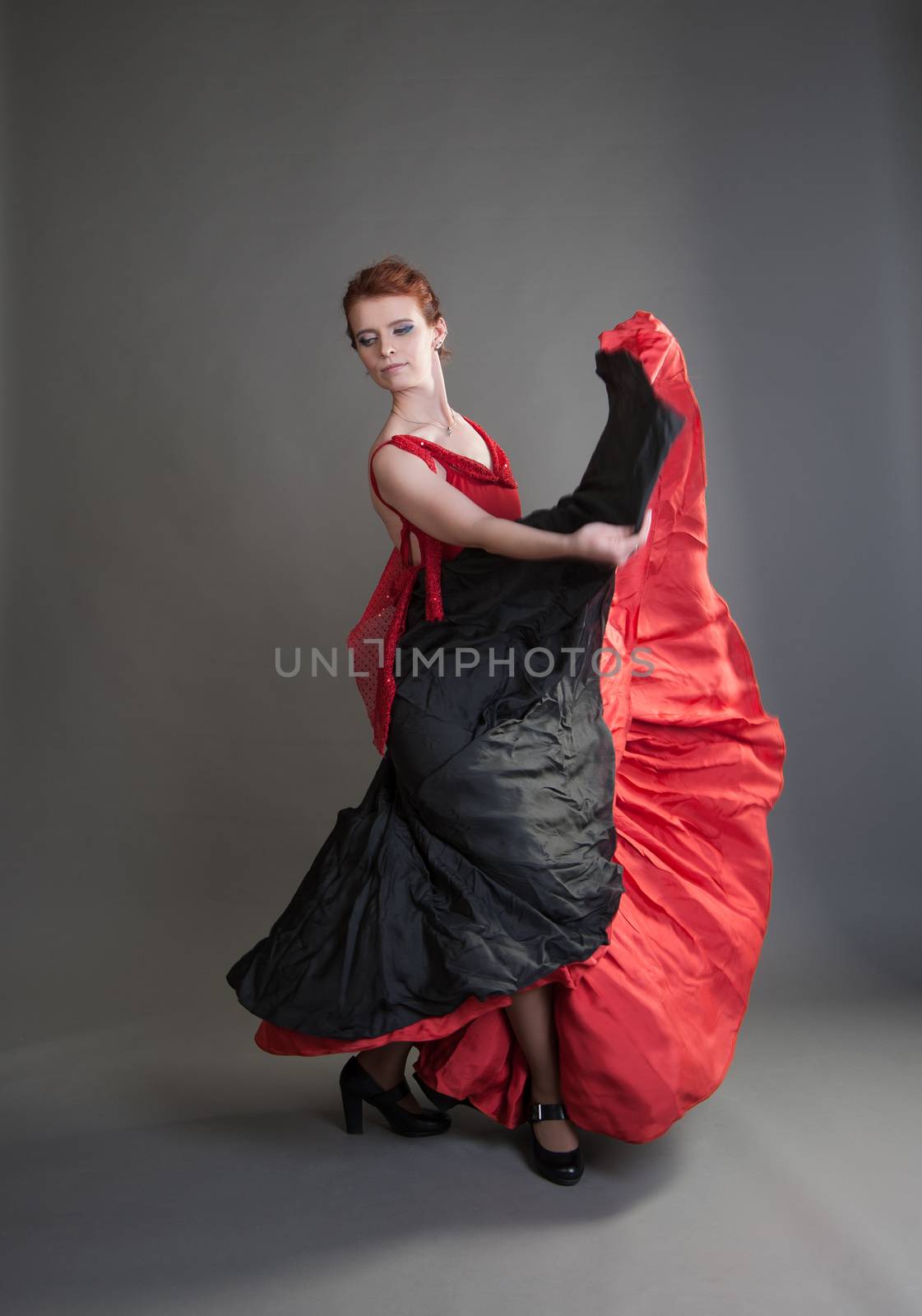 flamenco dancer swinging skirt on a grey background