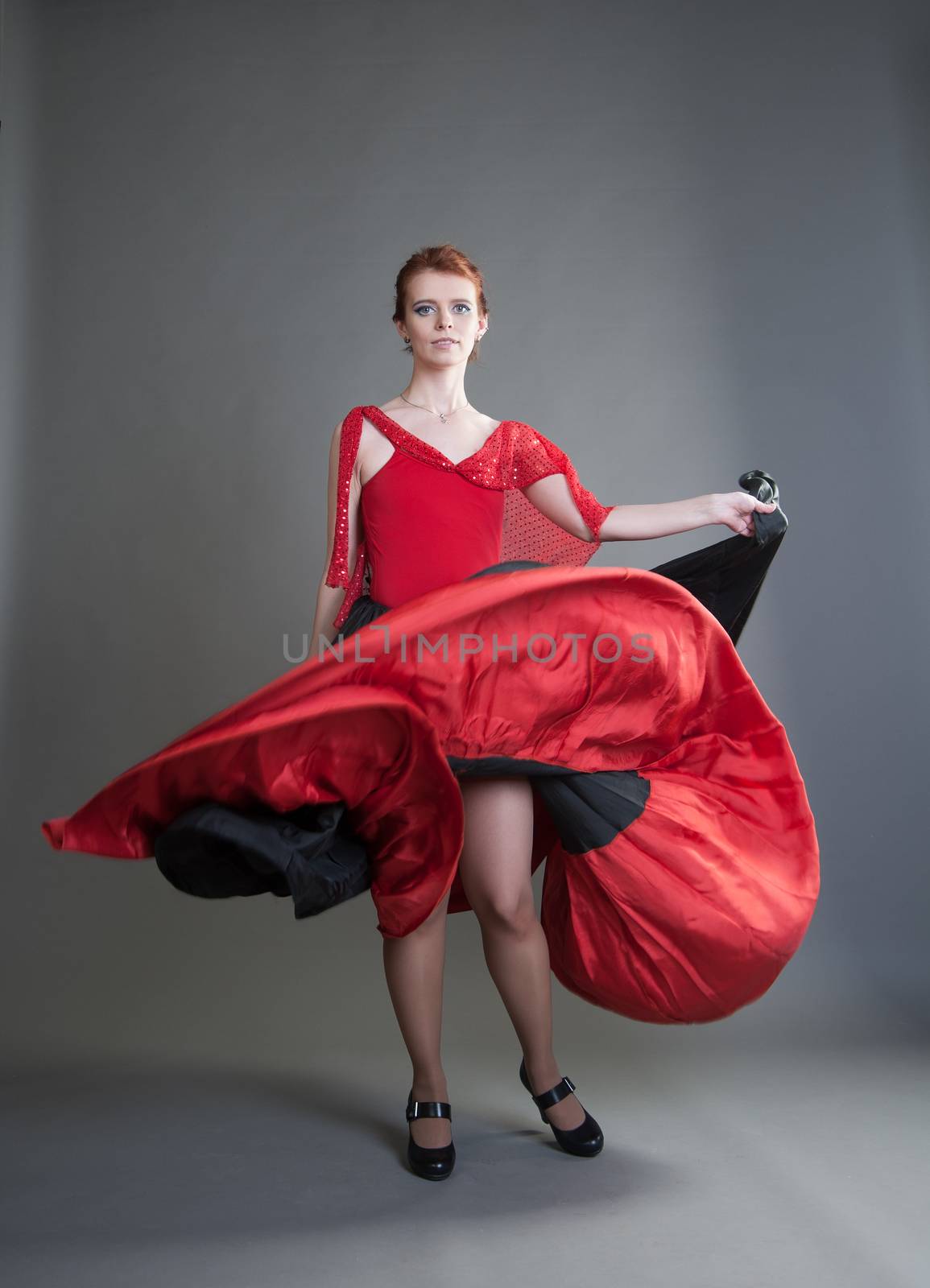 flamenco dancer swinging skirt on a grey background