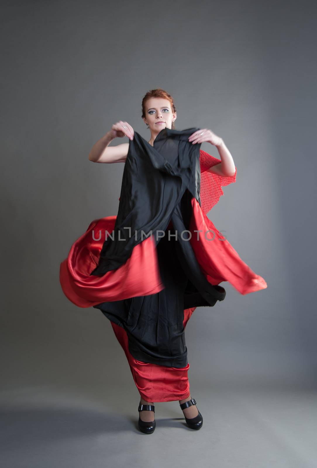 flamenco dancer swinging skirt on a grey background