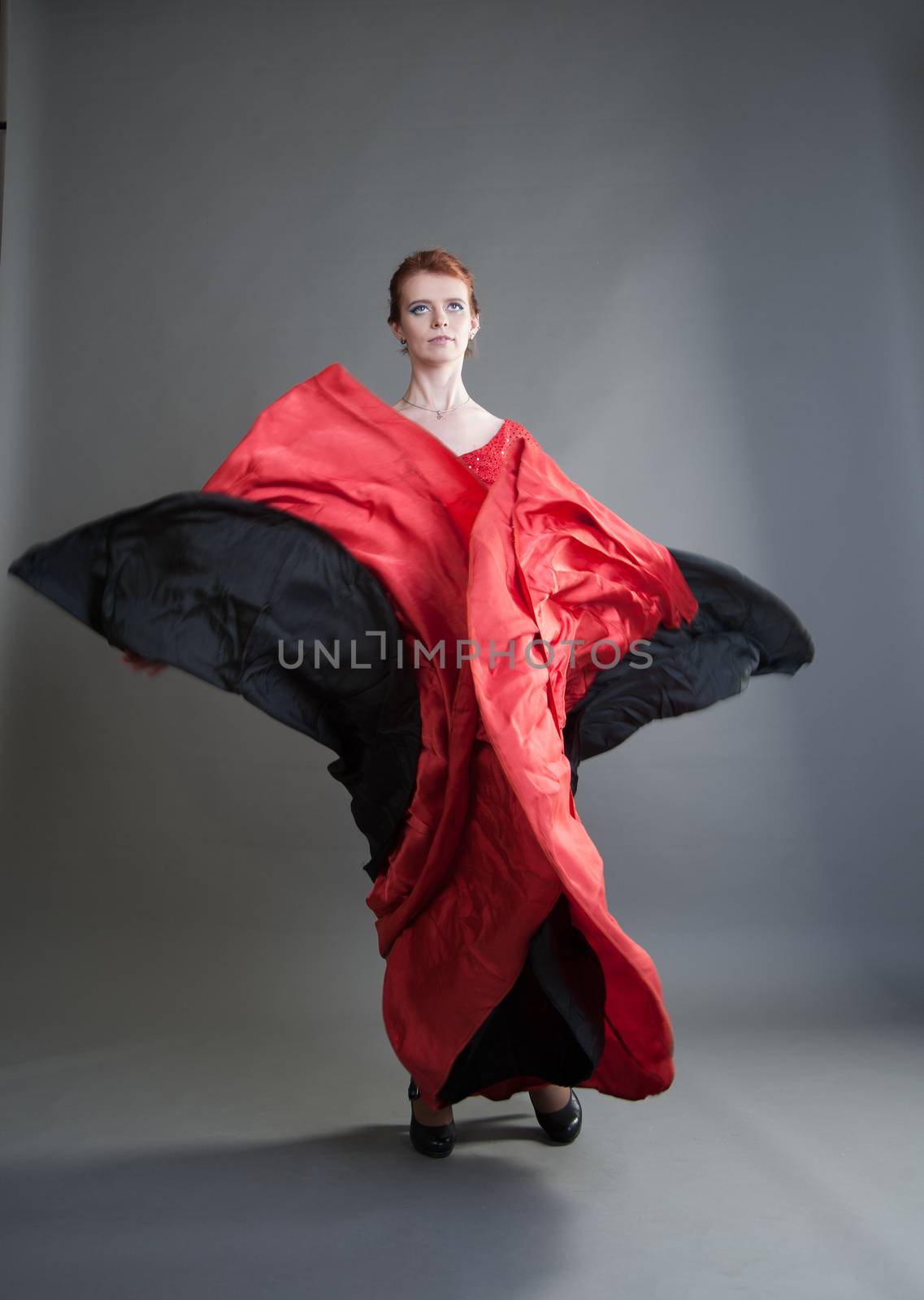 flamenco dancer swinging skirt on a grey background