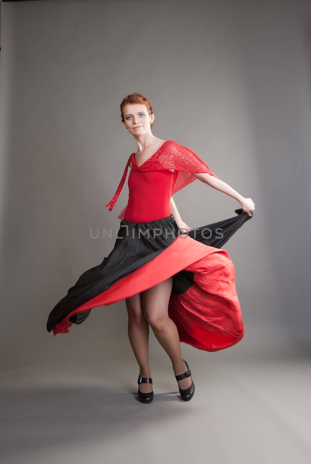 flamenco dancer swinging skirt on a grey background