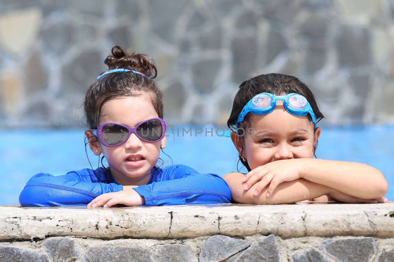 Portrait of two little girls in the pool by dacasdo