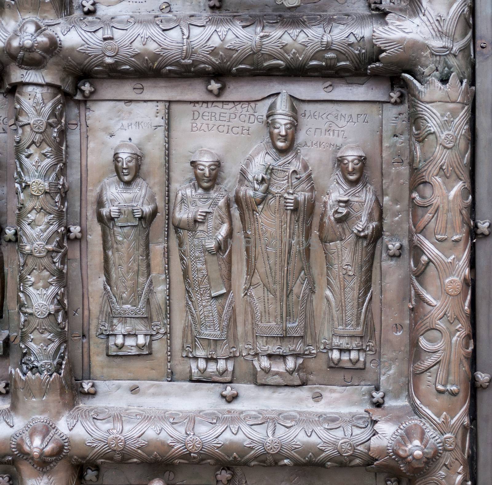 Ancient bronze gates of Magdeburg in Veliky Novgorod, Russia. Fragment of the bas-relief with bishop Alexander and deacons.