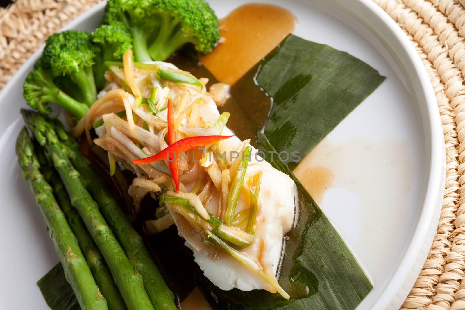 Freshly prepared Thai style sea bass fish dinner with asparagus and appetizer with a contemporary presentation.
