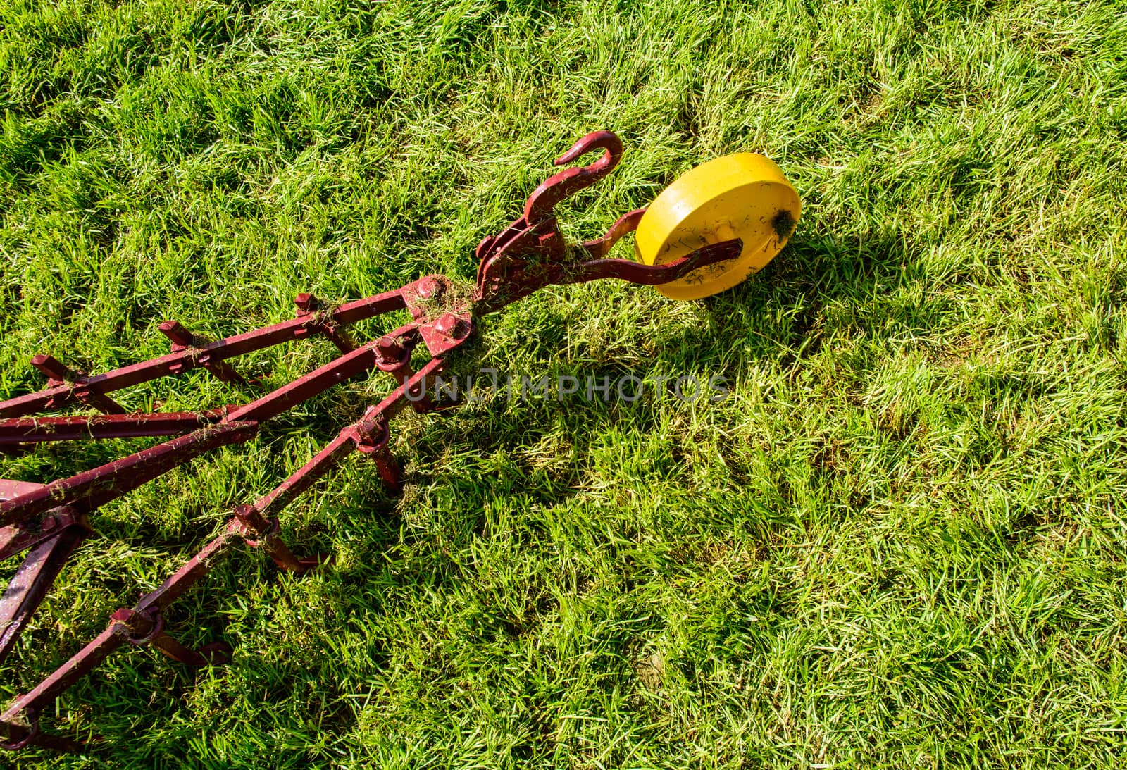 Farming tool on the green field is waiting to be used