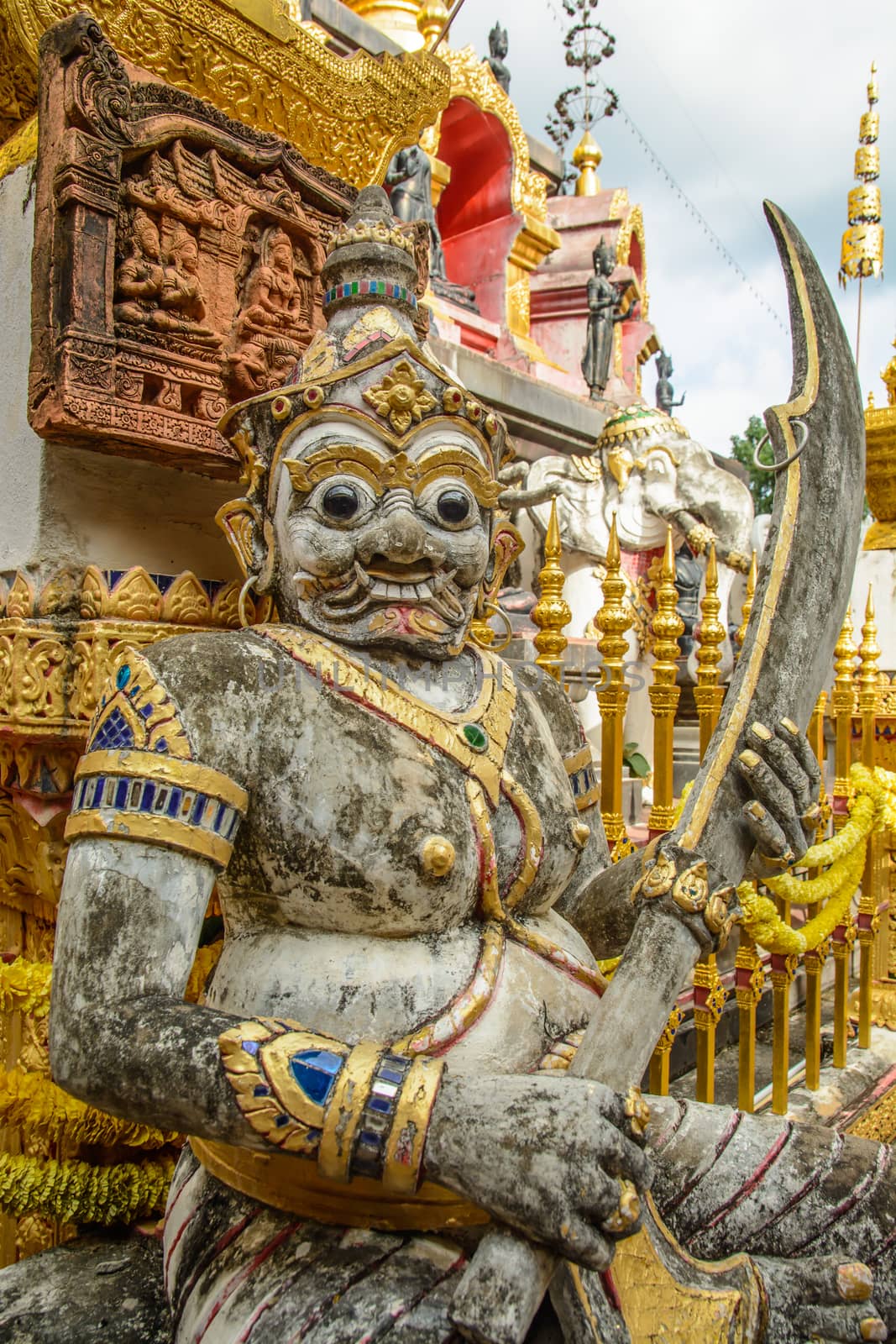 The giant protector with sword in front of the Thai temple.