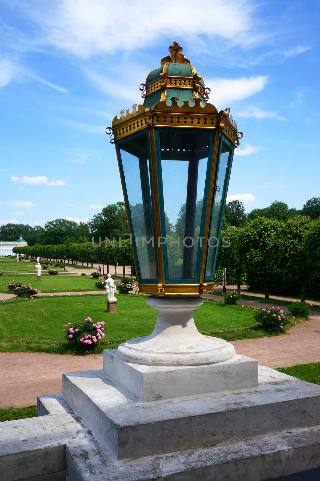 Large glass lantern on the balustrade of the palace on a background of park                               