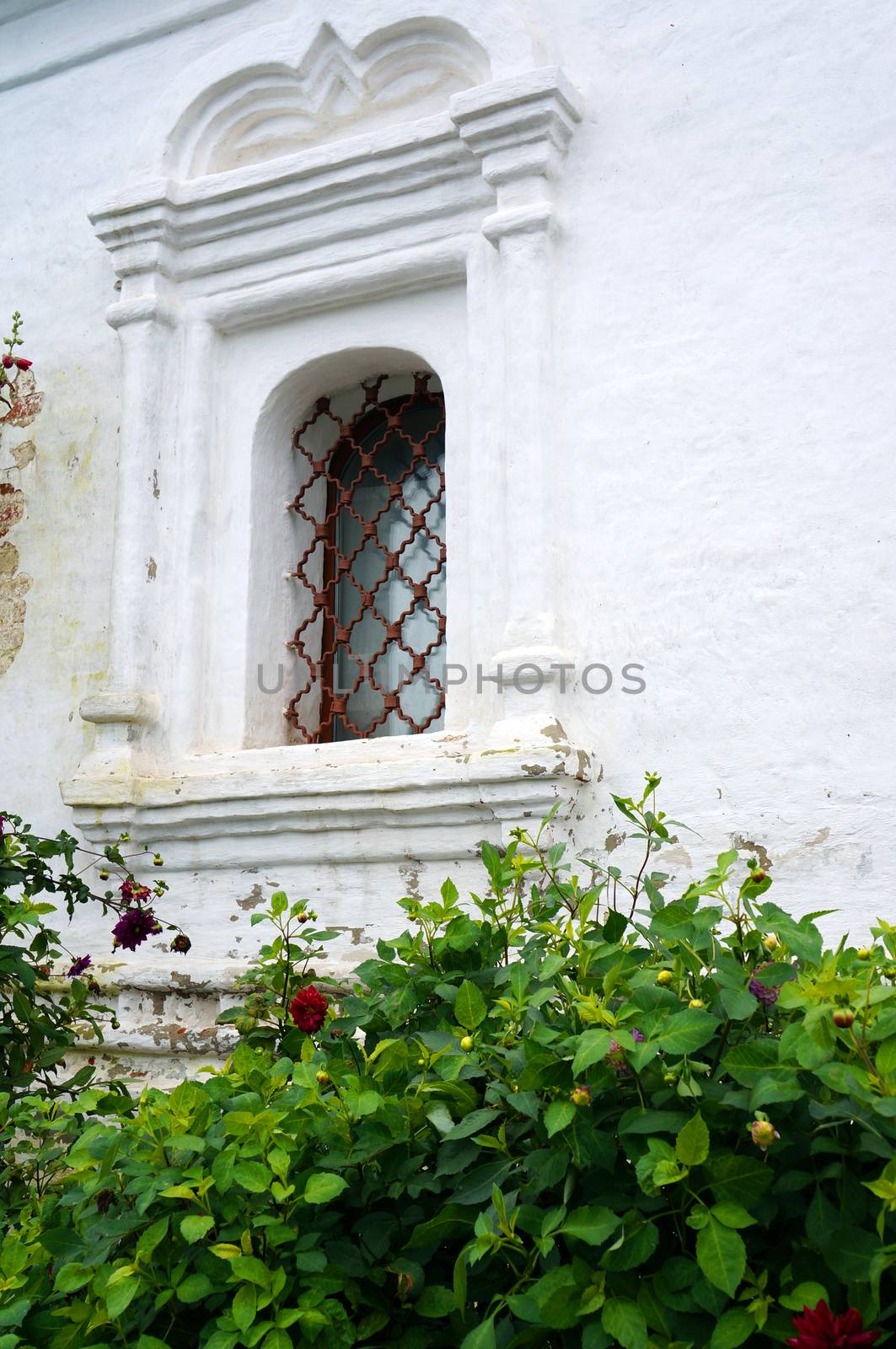 Barred window - Detail of an old white church                               