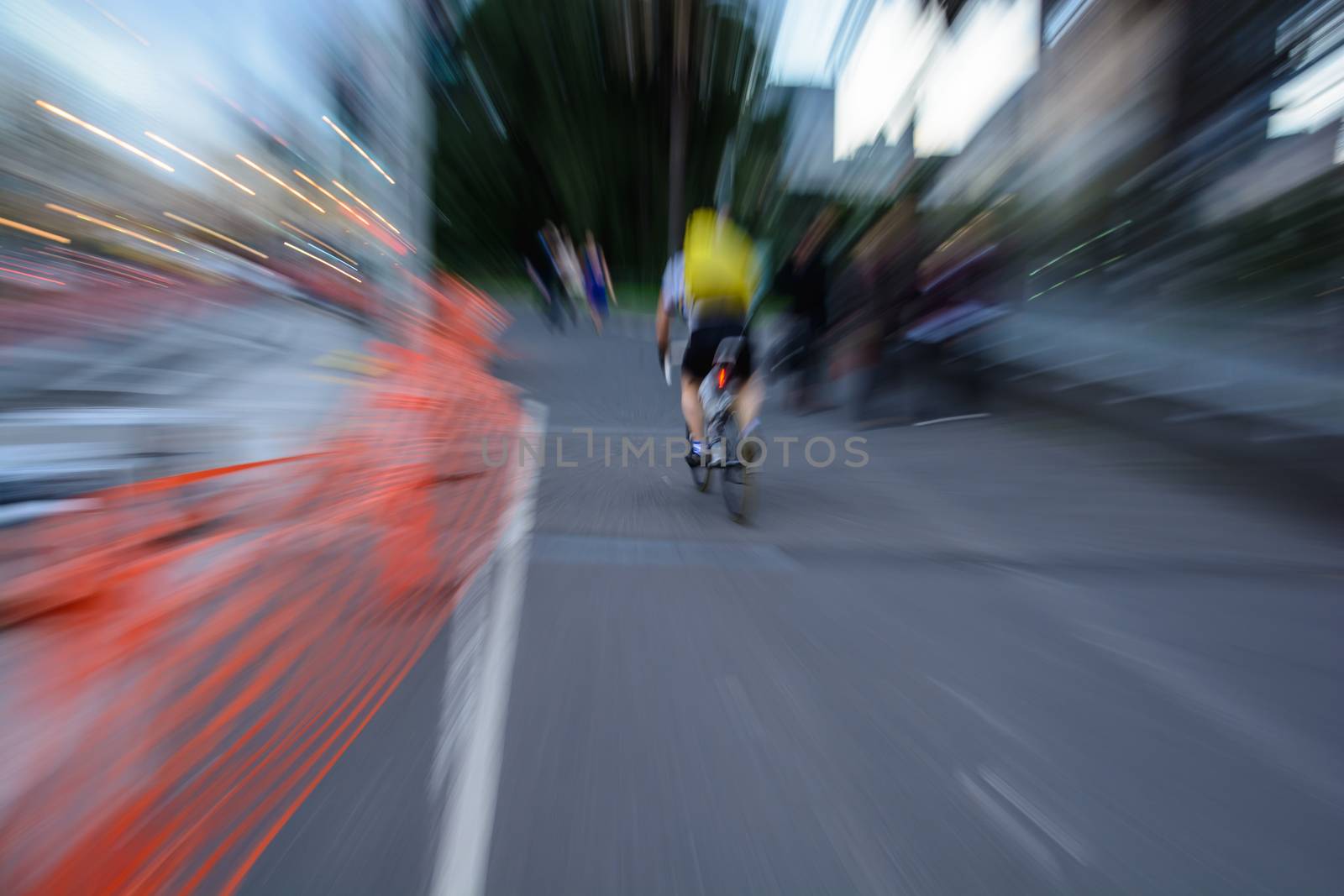 A man riding bicycle on the street with the fast speed.