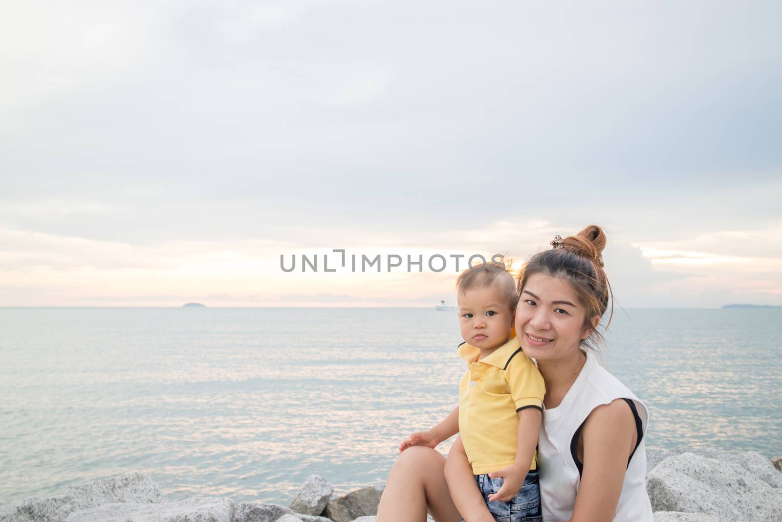 Asian boy pose on the beach with his mother, stock photo