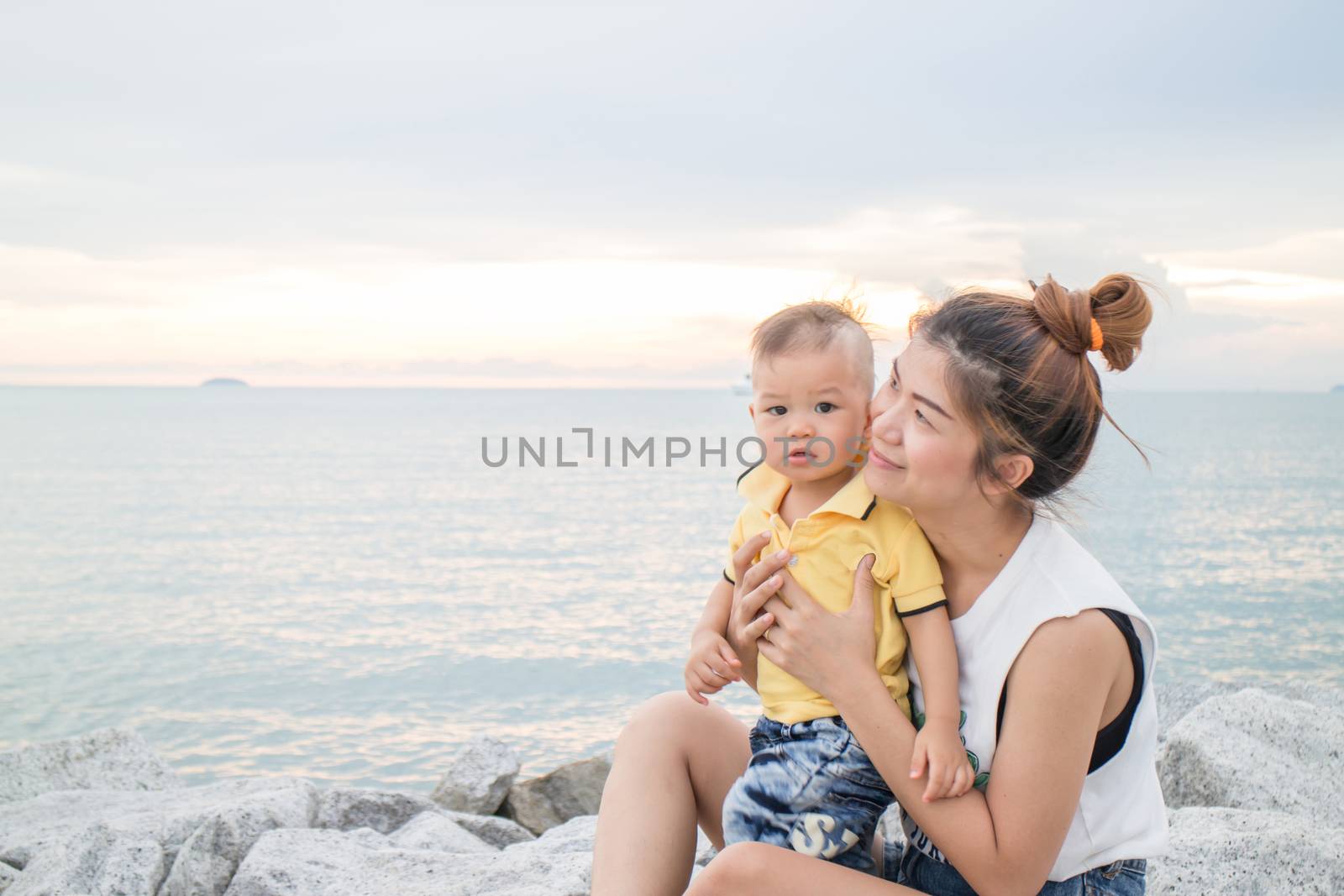 Cute boy pose on the beach with his mother, stock photo