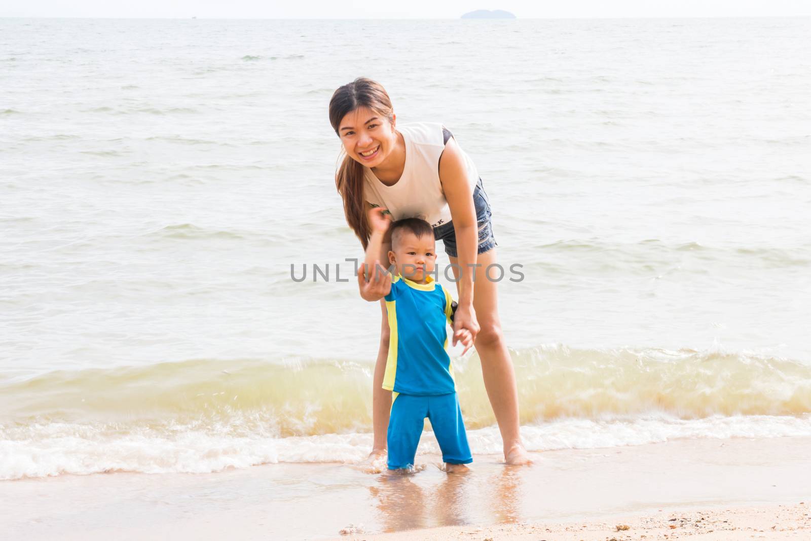 Mom and son chill on the beach, stock photo