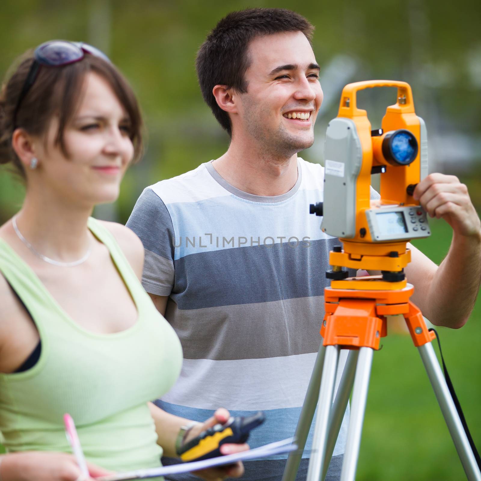 Two young land surveyors at work