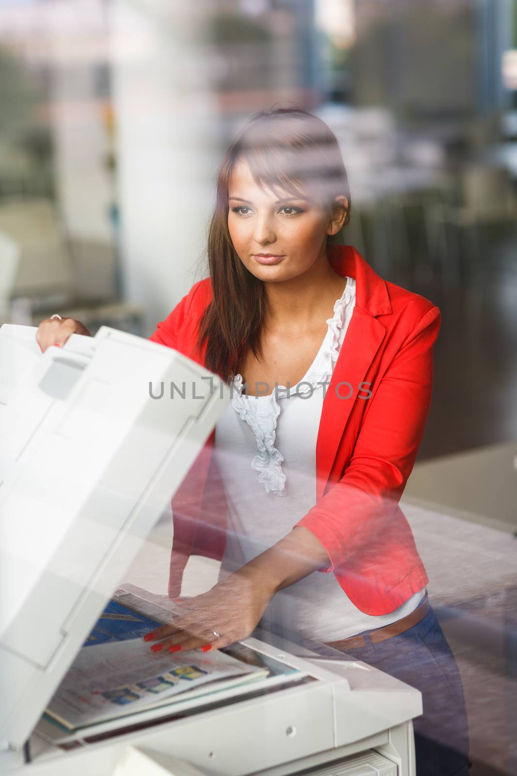 Pretty young female college student/secretary using a copy machine (shallow DOF; color toned image)