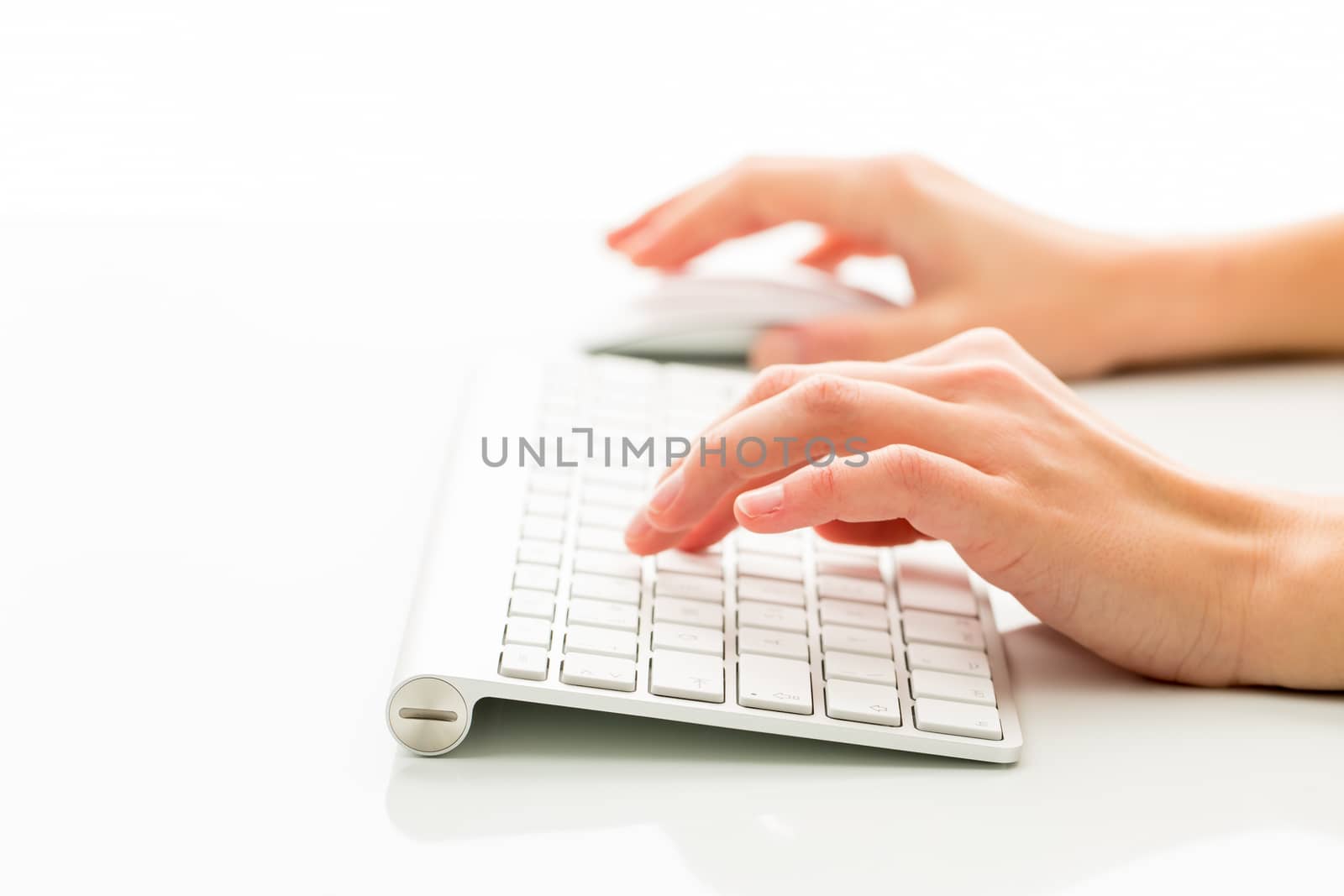 Hands of a person working an a keyboard over white background by viktor_cap