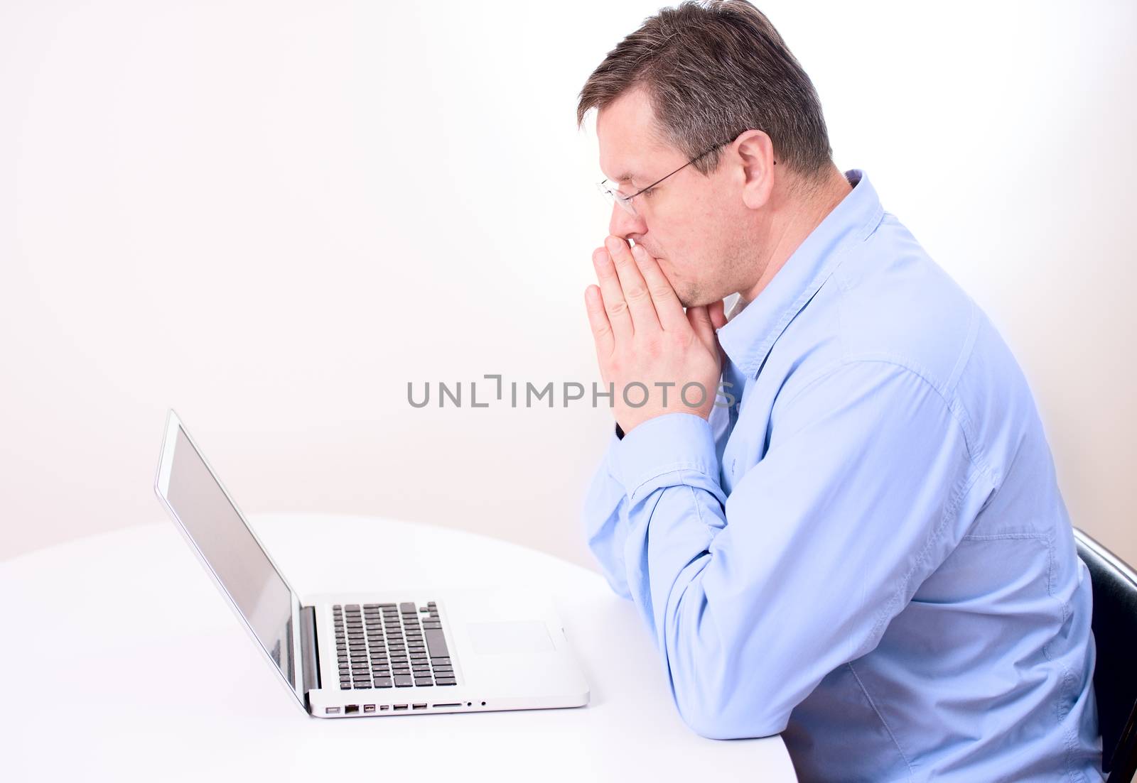 Man thinking hard on front of laptop
