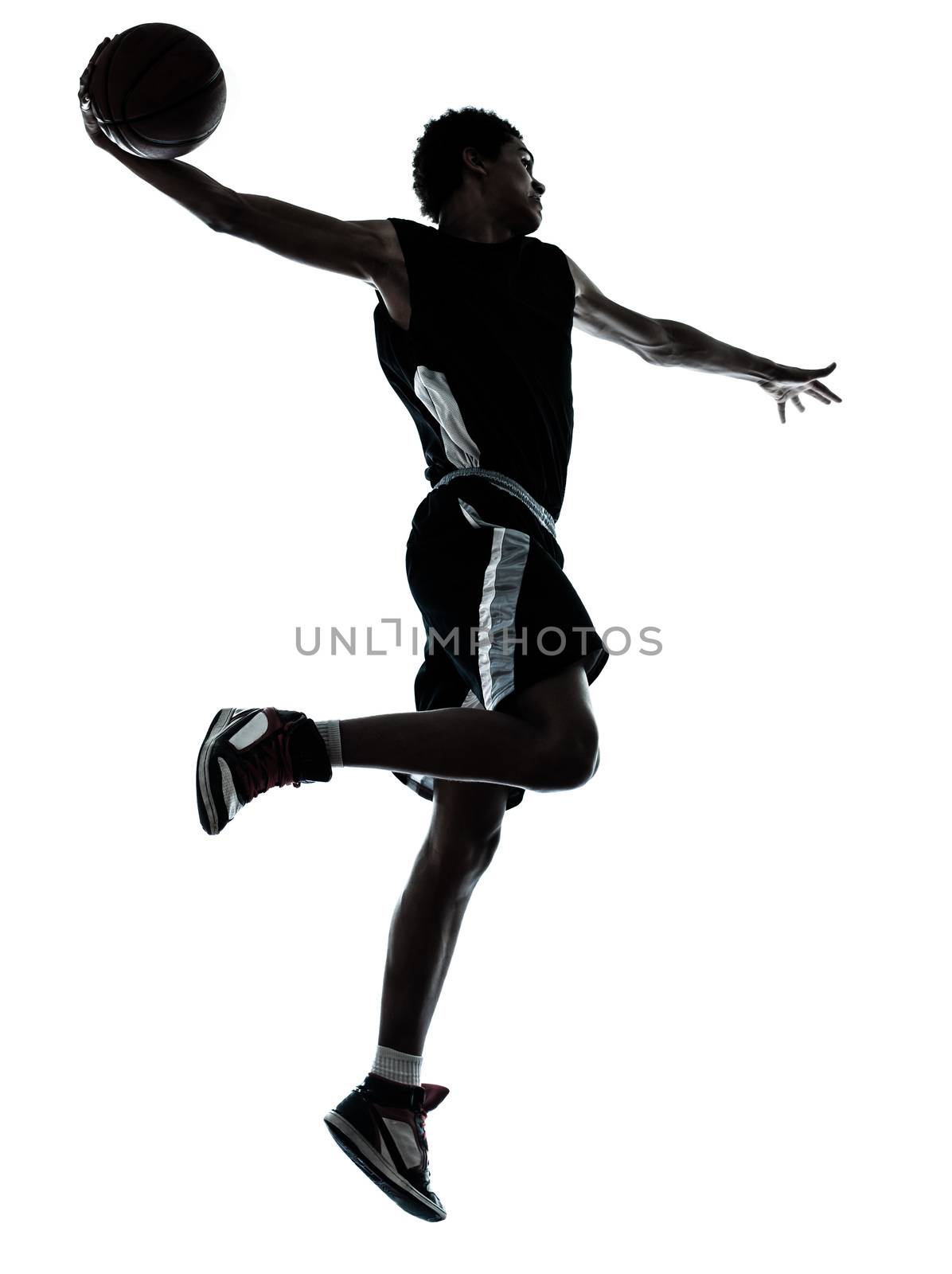 one young man basketball player one hand slam dunk silhouette in studio on white background