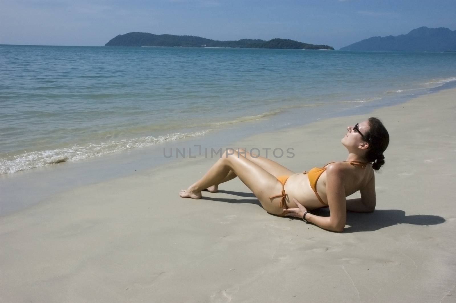 Sunbathing woman by seawaters