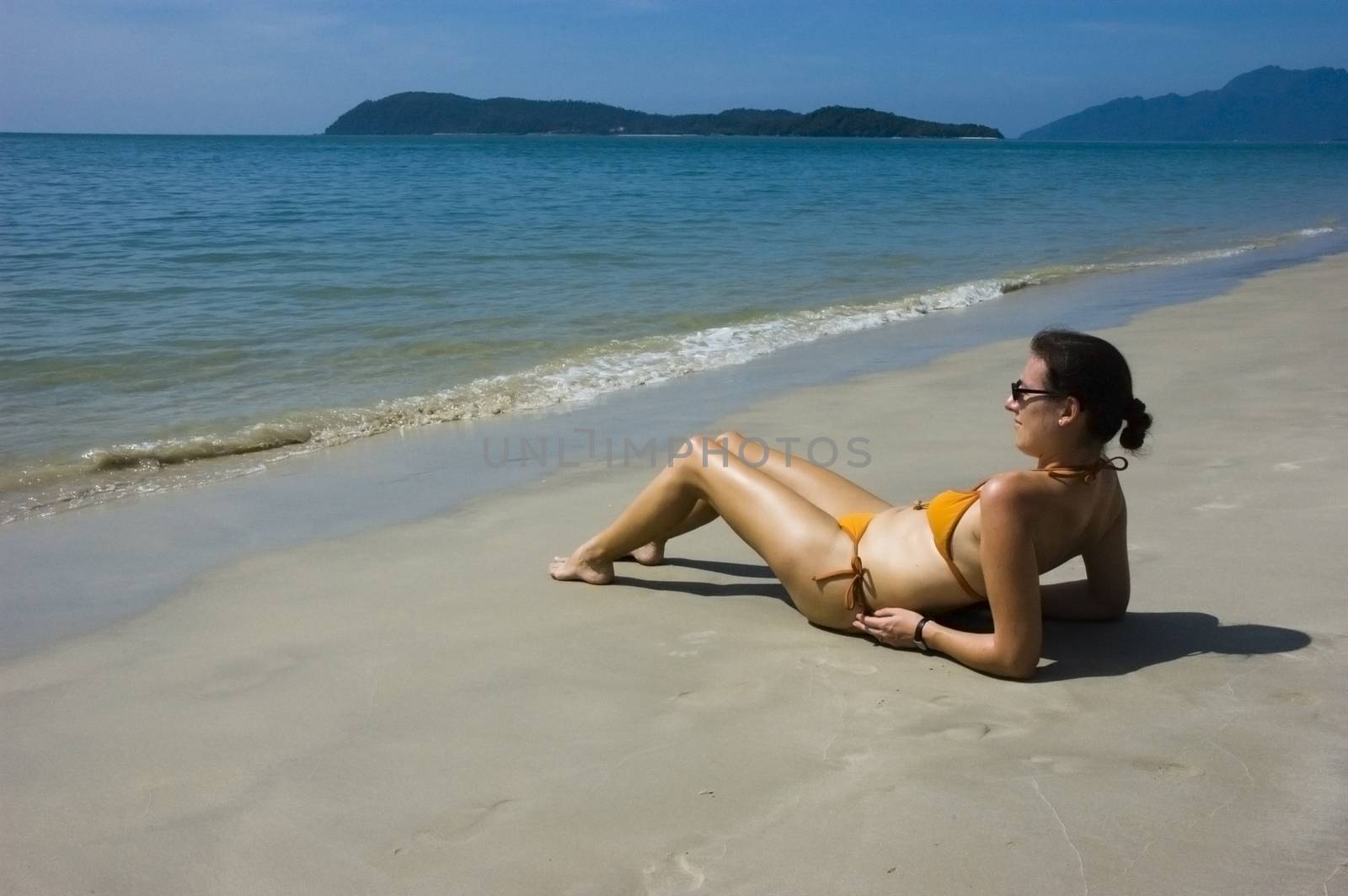 Sunbathing woman by seawaters